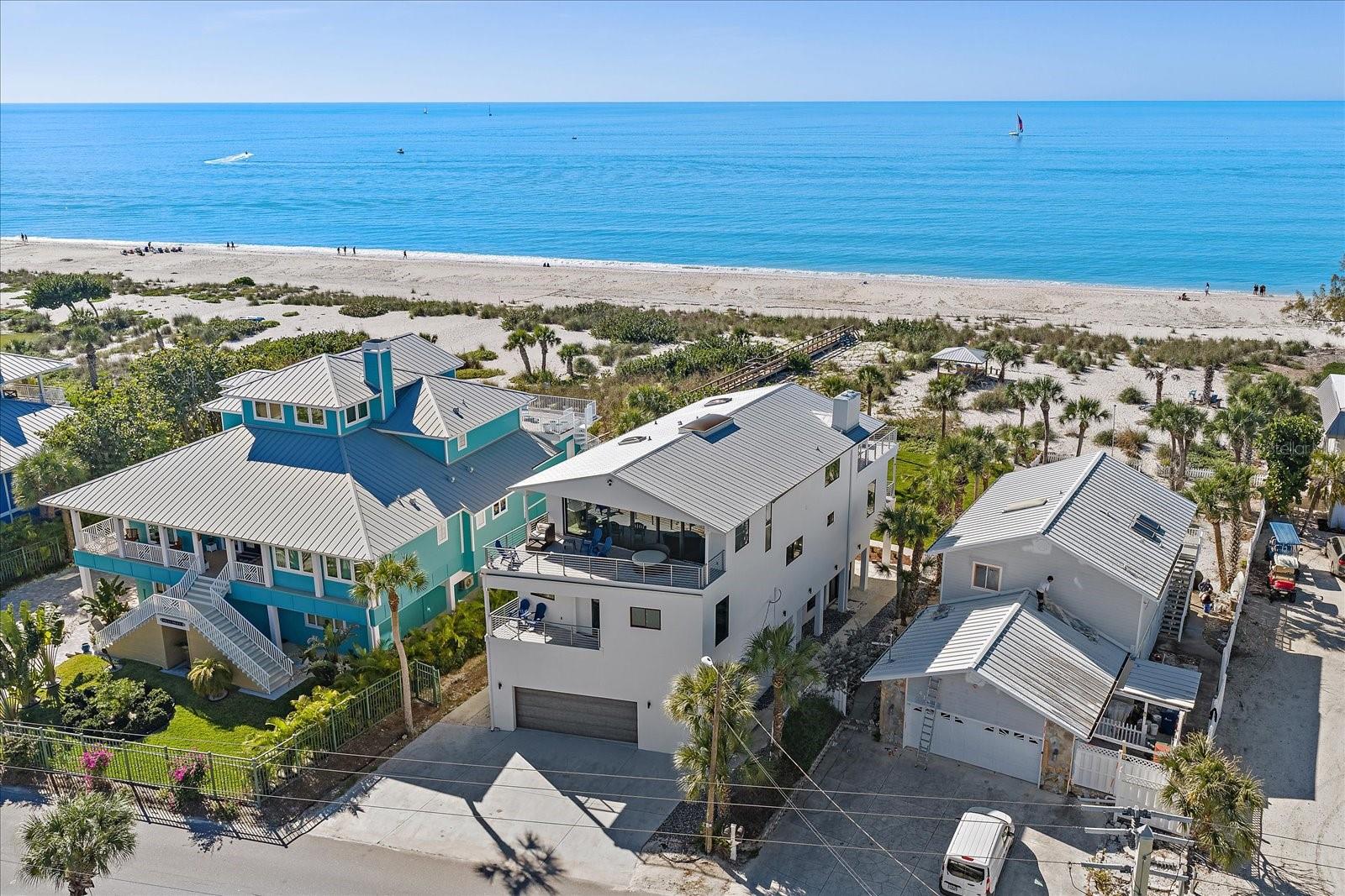 Wake up every morning to beautiful Gulf views from your third floor primary suite! Experience effortless luxury in this exceptional Gulf-front estate on the pristine shores of Casey Key, where privacy, tranquility, and sweeping water views await. Originally built in 1951 and tastefully renovated in 2016 and 2025, this beach-front residence seamlessly blends classic character with refined modern updates.

Offering nearly 4,000 square feet of living space under air, this home features 6 bedrooms and 4.5 bathrooms across three levels, designed for both comfort and entertaining. Generous room for hosting/gathering throughout with three expansive balconies inviting you to enjoy both breathtaking Gulf and intracoastal waterway views!

Thoughtfully designed in-law quarters on the first level with the second level featuring a gourmet chef’s kitchen, family room and additional guest rooms/baths. The chef's kitchen is equipped with a Wolf six-burner gas range with griddle and double oven, a Sub-Zero PRO refrigerator/freezer, granite countertops, soft-close cabinetry, and a large centerpiece island perfect for casual dining with a view.

The Owner's level on the third floor is to die for! Tremendous views of the Gulf from the substantial primary suite with this level also featuring a sitting area and den/office/bonus room that has views of the intracoastal waterway! The primary bathroom includes a stand-alone garden tub with skylight over, large walk-in glass and tile shower, dual vanities, and solid wood cabinets with granite countertops.

Additional highlights include impact windows and doors, travertine flooring throughout (with the exception of engineered hardwood in the kitchen), marble-tiled baths, and a 2-car garage.

Recent improvements include a new metal roof (2025), new sod/landscaping/irrigation (2025), fresh paint inside and out (2025), a new septic system (2025) and A/C system (2023), offering peace of mind for years to come. Offered turnkey furnished. With private beach access steps away, this is a rare opportunity to own a truly remarkable waterfront retreat on one of Florida’s most desirable barrier islands! Call today for more information or to set up a private tour! **THIS PROPERTY QUALIFIES FOR A 1% LENDER INCENTIVE IF USING PREFERRED LENDER. INQUIRE FOR MORE DETAILS.**