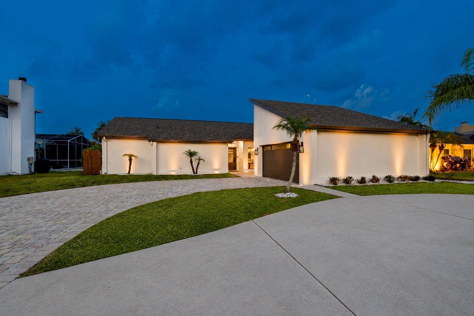 Nestled within the highly sought-after gated community of Bayside, this beautifully updated waterfront residence offers the perfect blend of luxury, comfort, and the ultimate Florida lifestyle. Featuring 3 bedrooms, 2 bathrooms, a 2-car garage, and 2,033 square feet of thoughtfully designed living space, every detail of this home has been meticulously enhanced for modern living. An impressive, oversized paver driveway, complemented by an additional circular drive, creates exceptional curb appeal and ample parking for family and guests. Inside, the expansive open-concept floor plan is flooded with natural light, creating an inviting atmosphere that is ideal for both everyday living and effortless entertaining. The home has been tastefully updated from top to bottom, offering a truly move-in-ready experience. At the heart of the home is a stunning kitchen designed for gathering and entertaining, featuring quartz countertops, a large center island, a beautiful designer backsplash, stainless steel appliances, an oversized double farmhouse sink, and seamless sightlines into the main living spaces. The spacious living area is anchored by a charming wood-burning fireplace and complemented by a stylish bar with a wine refrigerator, creating the perfect setting for hosting family and friends. The luxurious primary suite serves as a private retreat, offering tranquil canal views, a custom-built walk-in closet, and a fully remodeled spa-inspired bathroom complete with dual vanities, a freestanding soaking tub, a spacious glass-enclosed shower, and sleek contemporary finishes. The secondary bedrooms are generously sized with ample closet space, providing comfort and flexibility for family and guests alike. Step outside to your own waterfront paradise, where a sprawling party deck and covered patio create the perfect setting for year-round entertaining. A brand-new 13,000-pound boat lift, installed in 2025, provides quick and easy access to the open waters of Tampa Bay, allowing you to enjoy everything the waterfront lifestyle has to offer, from sunset cruises and waterfront dining to some of the area’s best boating and fishing. Recent improvements provide peace of mind and exceptional value, including a new roof, gutters, and exterior paint (2026), a new front door (2025), a new chimney cap (2026), a new garage door opener (2026), a water softener (2023), exterior dusk-to-dawn lighting (2022), & motorized shades (2022). Perfectly positioned near Tampa International Airport, beautiful Gulf beaches, premier shopping, medical facilities, exceptional dining, and great schools, this remarkable waterfront home delivers the very best of luxury living in one of Tampa’s most desirable gated communities. Make your private appointment today!