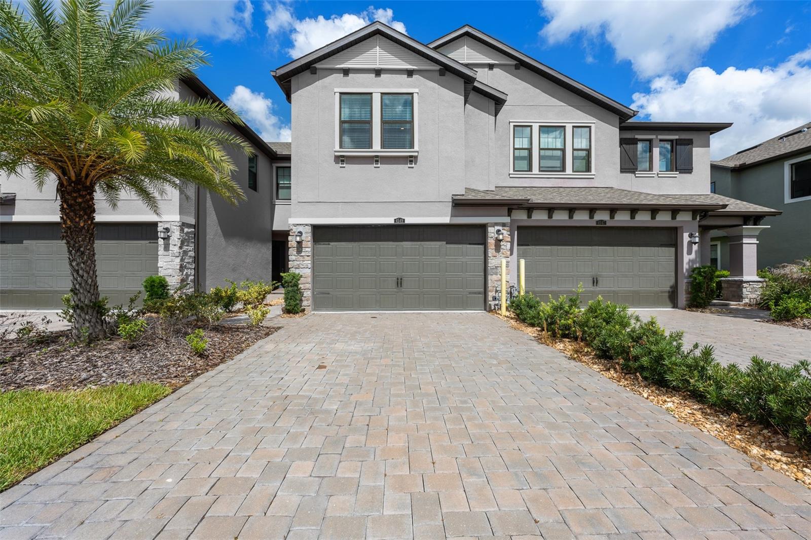 Experience luxury townhome living in the highly sought-after Estancia at Wiregrass master-planned community in the exclusive Sortino Townhome section. From the moment you enter Estancia, you are welcomed by an upscale atmosphere featuring beautifully landscaped walking paths, tree-lined streets, elegant Tuscan-inspired brick walls, and charming decorative lamp posts throughout the neighborhood. Known as some of the most sophisticated townhomes in Wesley Chapel, Sortino offers an exceptional lifestyle surrounded by both gated and non-gated luxury sections, including estate homes valued at over $1 million. Residents enjoy access to one of Tampa Bay’s premier clubhouses, complete with a spectacular resort-style pool featuring a towering super slide, zero-entry access, traditional swim areas, and a separate lap pool with diving boards for organized swimming activities. The community also offers playgrounds, tennis courts, pickleball courts, basketball courts, and endless opportunities for recreation and relaxation for every member of the family. This stunning 3-bedroom, 2.5-bath townhome showcases upgraded designer finishes rarely found in townhomes throughout the area. The gourmet kitchen features quartz countertops, a slide-in gas range, beautiful wood-look tile flooring throughout the first floor, and both an eat-in kitchen space plus a separate dinette area overlooking the spacious family room and sliding glass doors leading to the covered lanai. You will be amazed by the abundance of storage and closet space throughout the home, especially in the oversized 2-car garage featuring epoxy floors and a large additional storage closet. Additional upgrades include a tankless gas water heater and water softener system. Upstairs, retreat to the luxurious tray ceiling primary suite with a beautifully upgraded spa-like bath featuring a large walk-in shower and separate vanities. No builder-grade finishes here — this home offers the elevated style and quality today’s buyers are searching for.