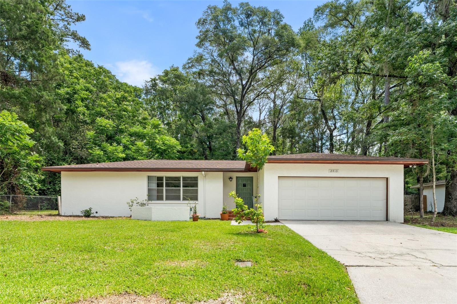 Virtually Staged. No HOA. Conveniently located in Wynwood Hills off NW 23rd Avenue, this charming 3-bedroom, 2-bath home offers a desirable split-bedroom floor plan filled with natural light. Multiple sets of sliding glass doors bring the beauty of the Florida landscape indoors, creating a bright and relaxing atmosphere throughout the home. The spacious layout includes a front living room as well as a comfortable family room just off the kitchen, which opens to a large screened porch overlooking the established fenced backyard—perfect for entertaining or enjoying peaceful mornings with coffee. Attached 2 car garage. 

Recent updates include new kitchen cabinets, new flooring in the kitchen and huge laundry room with new washer and dryer, a newly renovated tub/shower in the hall bathroom, a 2021 roof, and a 2021 water heater. New ceiling fans and lighting. The interior and exterior have been freshly painted, and the carpets have been professionally steam cleaned, making this home truly move-in ready.

Ideally situated just minutes from Thornebrook Village, Publix, Hidden Oak Elementary, Fort Clarke Middle School, Buchholz High School, Santa Fe College and approximately 5 miles from the University of Florida, this home combines comfort, convenience, and an excellent location. Schedule your private tour today!