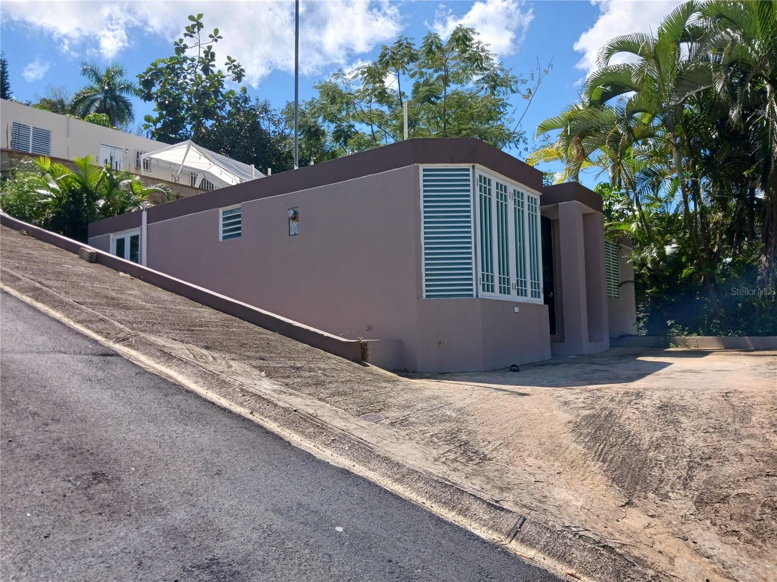 Located in the municipality of Bayamón, Puerto Rico, part of the larger San Juan metro area, with urban and suburban neighborhoods nearby including Río Hondo, Minillas, and Torres del Parque. This home sits on a 5,400 sqft lot within established residential areas, close to schools, shopping (like Santa Rosa Mall and Plaza Río Hondo), restaurants, and major roads. 2 bedrooms and 1 bath suitable for a couple, roommates, or a small family. Layout commonly includes a combined living/dining area, a kitchen, and a small porch. This  home is one-story and built with contrete construction — a common style across Puerto Rico designed for warm weather and hurricane resilience. There is space for outdoor seating, gardening, or parking. Move-in ready with included mini-split air-conditioning units.