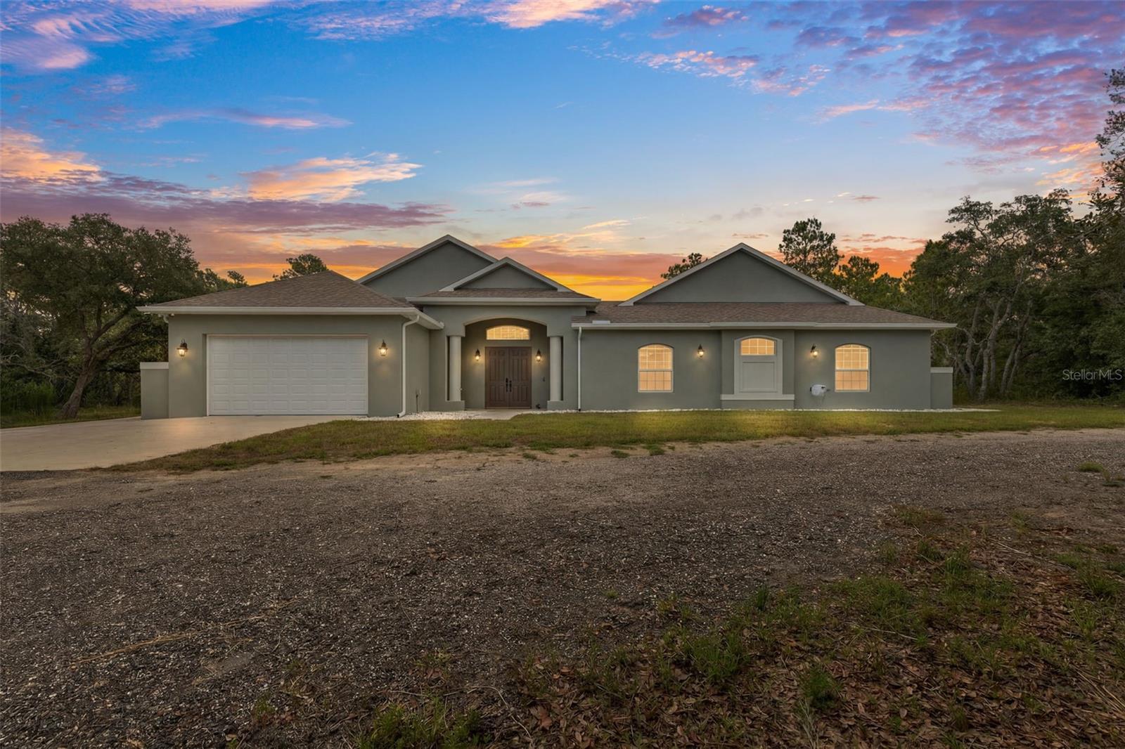 Listing agent is owner.  Gorgeous, brightly lit, custom home on 10.8 acres.

Rare courtyard design with beautiful, heated, salt infinity pool and overflow spa.  Control all aspects of the pool with your phone or tablet, including heat, lights, and run schedule.  Travertine block throughout the courtyard, entryway, and screened back lanai.

Appliances are high-end GE Café smart enabled, including a dual drawer dishwasher and built-in Keurig coffee maker in the refrigerator.  The hideaway range hood slides out to provide a clear, well-lit view of the induction cooktop.  The kitchen boasts 42” upper cabinets, lower cabinets have built-in wood shelf slides, a hidden spice rack, and concealed trash and recycle bins.

Main residence includes foam spray insulation throughout for improved energy efficiency, 10-foot ceilings, and porcelain tile throughout.  Each bathroom is tiled and styled differently, and a hot water circulation pump ensures rapid hot water availability.  Primary bedroom has huge closet with armoire storage system and built-in wall safe.  Primary bath has custom-built shower with a dedicated hot water heater, dual vanities, and a built-in wall heater for chilly mornings.  The guest suites are separate from the main house and have a separate mini-split for climate control.  Unique Minka-Aire ceiling fans are throughout the house and have in-wall controls.

The house is wired with network cables for security cameras and wireless access points.  The house is protected by a Ring alarm system and outside doors are equipped with a smart keypad.

Outside you’ll find the wooded property to be entirely fenced and protected by a front gate with a solar opener.  The back of the property shares a border with a blueberry farm.  Electrical service is 400 amp buried cable, complemented by 50 solar panels, which has resulted in the average electric bill being $135 over the last 12 months, including charging electric vehicles (Tesla charger in garage).
An enormous 1,800 square foot outbuilding provides plenty of space for additional vehicles and a sizeable workshop.  Building is foam insulated, has electricity, air conditioning, and water, along with three 10x10 rollup doors, which allows for comfortable year-round use.

Spectacular high-end home in a very private community where all your neighbors have their own 10 acres.