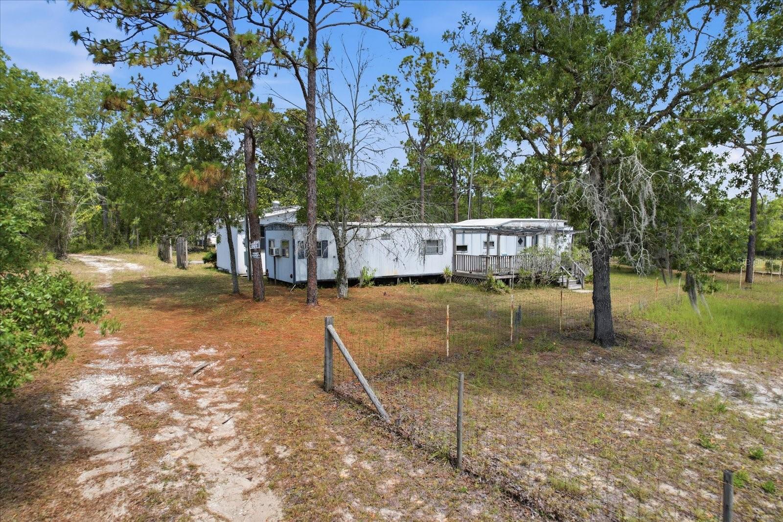 Affordable opportunity on 1.40 acres in Homosassa! This 2-bedroom, 1-bath mobile home is situated on a fully fenced parcel with plenty of room for animals, equipment, recreational vehicles, or outdoor hobbies. The property features a pole barn, storage shed, and a detached utility building equipped with electric and water. Multiple water spigots are located throughout the property for added convenience. Enjoy the privacy and flexibility of country living while remaining just minutes from the Suncoast Parkway, providing an easy commute to Tampa and surrounding areas. Conveniently located near shopping, dining, and the outdoor recreation the Nature Coast is known for. Whether you're looking for a primary residence, investment property, or a property with room to grow, this one offers plenty of potential. Property is being sold as-is. Buyer to verify all information and intended uses.