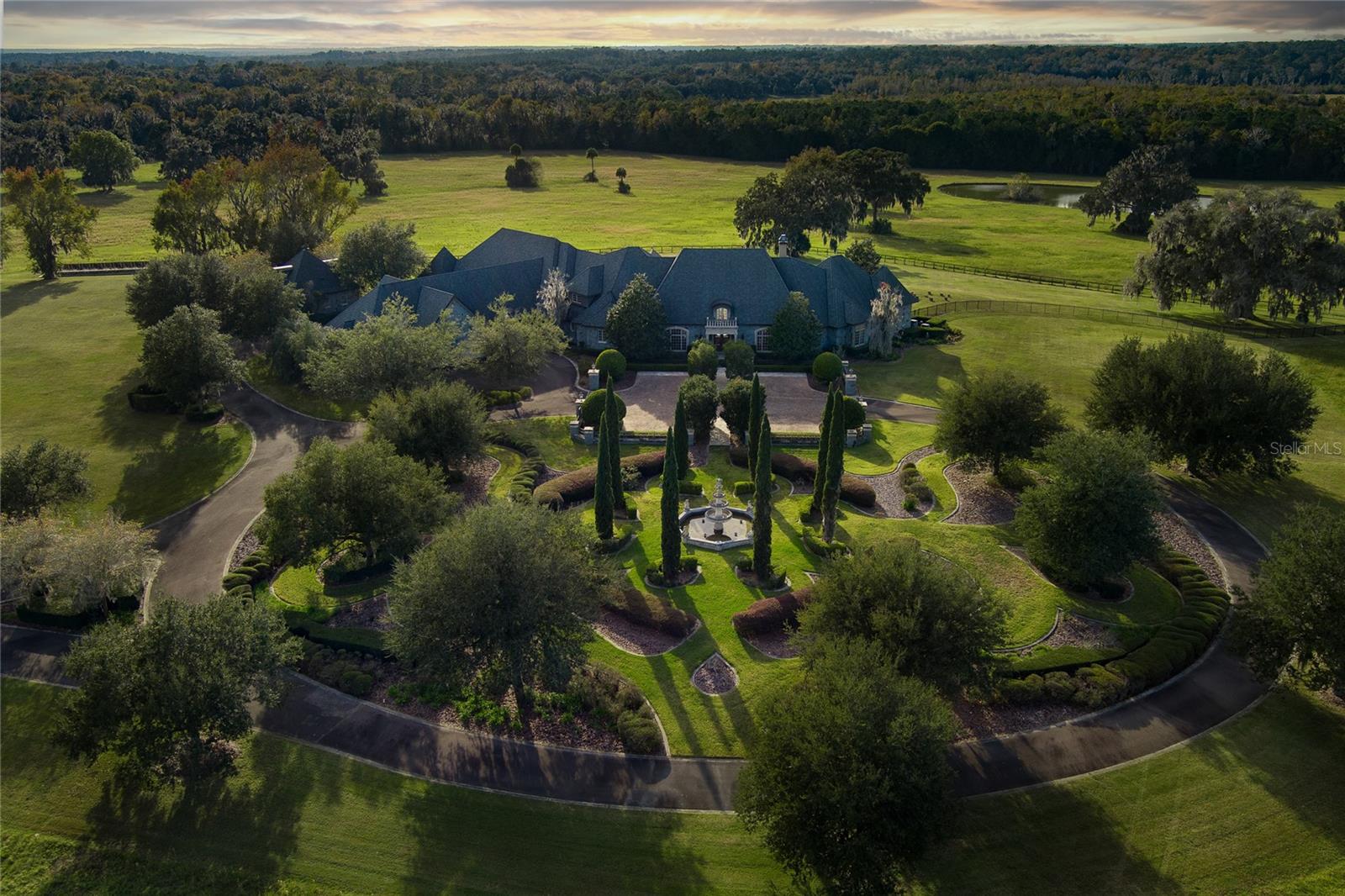 A rare opportunity awaits atop one of the region's highest elevations where this magnificent 560+ acre estate commands breathtaking panoramic views of Florida's pristine countryside. Mardanza Farm features a masterfully-crafted French Provincial main residence showcases exceptional design elements and superior craftsmanship, complemented by extensive additional accommodations across the property. Entertaining reaches new heights with the chef's kitchen, butler's pantry, and luxurious outdoor living area centered around a stunning infinity pool that seemingly merges with the horizon. For equestrian enthusiasts, the property's world-class facilities include four comprehensive barn complexes with integrated living quarters, lush pastures shaded by granddaddy oaks, and a professionally installed sport-horse arena. This extraordinary compound offers multiple luxury residences including a three-bedroom guest house and an elegant duplex with dual primary suites, creating the perfect blend of sophisticated living and equestrian excellence.