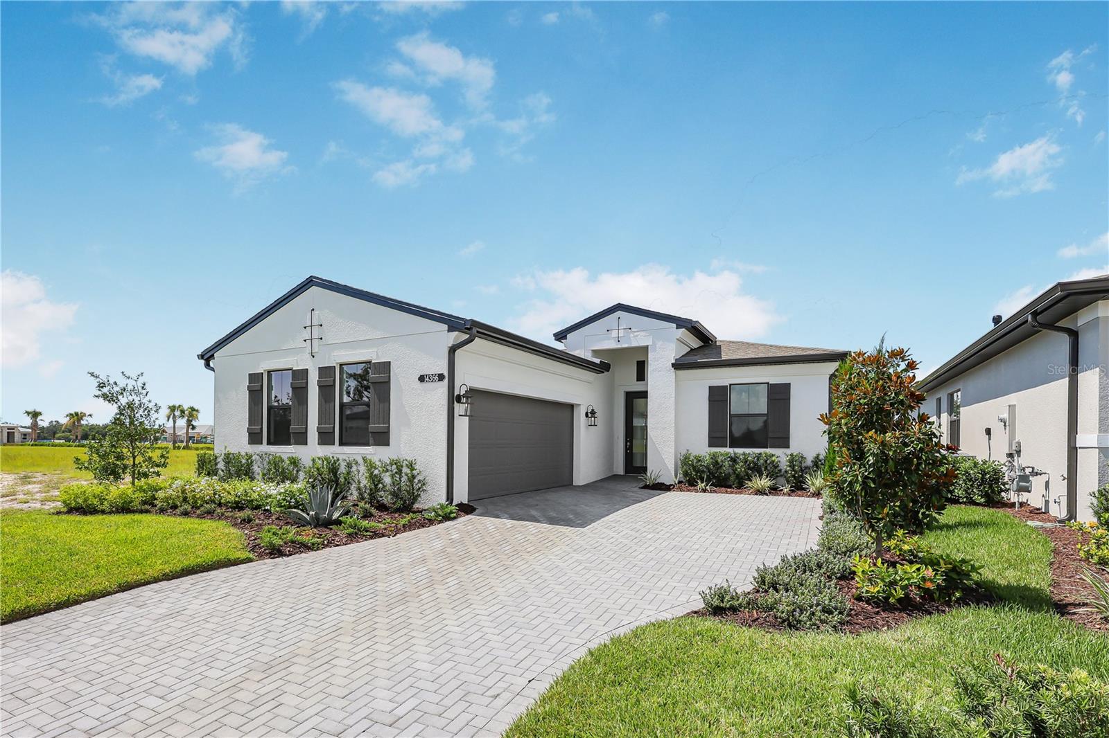 Move-in Ready! Welcome to Woodland Preserve, a premier 55+ active adult community in Parrish. Woodland Preserve offers boutique-style living with a brand new Community Center featuring a resort-style pool, hot tub, fitness and yoga studios, card and billiards rooms, pickleball and bocce courts, green space, and a walking trail. Conveniently located near Lakewood Ranch, Bradenton, Sarasota, Gulf Coast beaches, shopping, dining, parks, and medical facilities. Beautifully upgraded Laura floor plan featuring 3 bedrooms, 3 baths, and a versatile flex space on a premium homesite with serene pond views and desirable southern rear exposure. The open great room flows into a gourmet kitchen with 3cm quartz countertops, 36" cooktop, double ovens, soft-close cabinetry, pot & pan drawers, double trash pull-out, base rollouts, upgraded crown moulding, and a designer hood. Interior upgrades include large-format tile, wood-laminate plank flooring, additional recessed lighting, brushed-nickel hardware, and luxury frameless glass showers in the owner’s bath and Bath 3. A spacious covered lanai extends the living space outdoors, offering the perfect spot to enjoy peaceful water views. Move-in ready with premium finishes throughout.