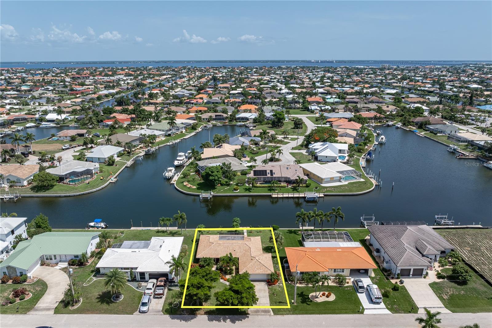 QUICK SAIL ACCESS, NEW TILE ROOF & UPDATED INTERIOR IN PGI - Move right into this updated, 3 bed/2 bath waterfront home in Punta Gorda Isles offering 80 ft of seawall, a 15 ft concrete dock, and quick sailboat access to Charlotte Harbor in under 15 minutes. Nestled on a quiet canal with desirable northern rear exposure, the home enjoys comfortable afternoon shade across the screened lanai, creating the ideal setting for year-round outdoor living. Inside, the open floor plan seamlessly connects the living, dining and kitchen areas, creating a bright, inviting space for everyday living and entertaining. Large windows and sliding glass doors fill the home with natural light while wood-look plank tile flooring, recessed lighting and contemporary fixtures create a clean, coastal feel throughout. At the heart of the home, the updated kitchen features white cabinetry, quartz countertops, a chevron-pattern subway tile backsplash, stainless steel appliances, and an oversized breakfast bar perfect for gathering with family and friends. The split-bedroom floor plan provides privacy for owners and guests alike. The spacious master suite offers an updated en-suite bath with quartz counters and modern finishes, while two generously sized guest bedrooms share a beautifully renovated guest bath. Sliding glass doors extend the living space onto the spacious screened lanai overlooking the tranquil canal. Enjoy morning coffee, evening cocktails, or simply relax while watching the boats pass by. The fenced backyard offers plenty of room to add the pool of your dreams, while the concrete dock is just steps away, keeping your boat ready for the next adventure. Reach Charlotte Harbor in less than 15 minutes and enjoy some of the finest boating, fishing, and waterfront dining Southwest Florida has to offer. Completely remodeled in 2018, the home was replumbed with PEX plumbing and extensively updated throughout with refreshed interior and exterior paint, updated woodwork, recessed lighting, fixtures, irrigation system, water heater, hurricane impact-resistant front door, and garage door opener. Recent improvements include a NEW TILE ROOF (2023), NEW refrigerator, NEW lanai refrigerator, and NEW washing machine. Additional amenities include an attached two-car garage and lush, tropical landscaping. Optional membership in the Punta Gorda Isles Civic Association (PGICA) opens the door to dozens of clubs and activities including boating, cards, travel, and more. The popular Newcomers Club makes it easy to meet neighbors and quickly feel at home in the community. Beyond its renowned boating lifestyle, Punta Gorda offers exceptional golf, pickleball, tennis, kayaking, cycling, and a vibrant calendar of festivals, concerts, and art events throughout historic downtown and the city's beautiful waterfront parks. Miles of sidewalks connect the neighborhood to Fishermen's Village, the Isles Yacht Club, St. Andrews South Golf Club, parks, restaurants, and downtown Punta Gorda. Make an appointment today and start living your Florida dream.
