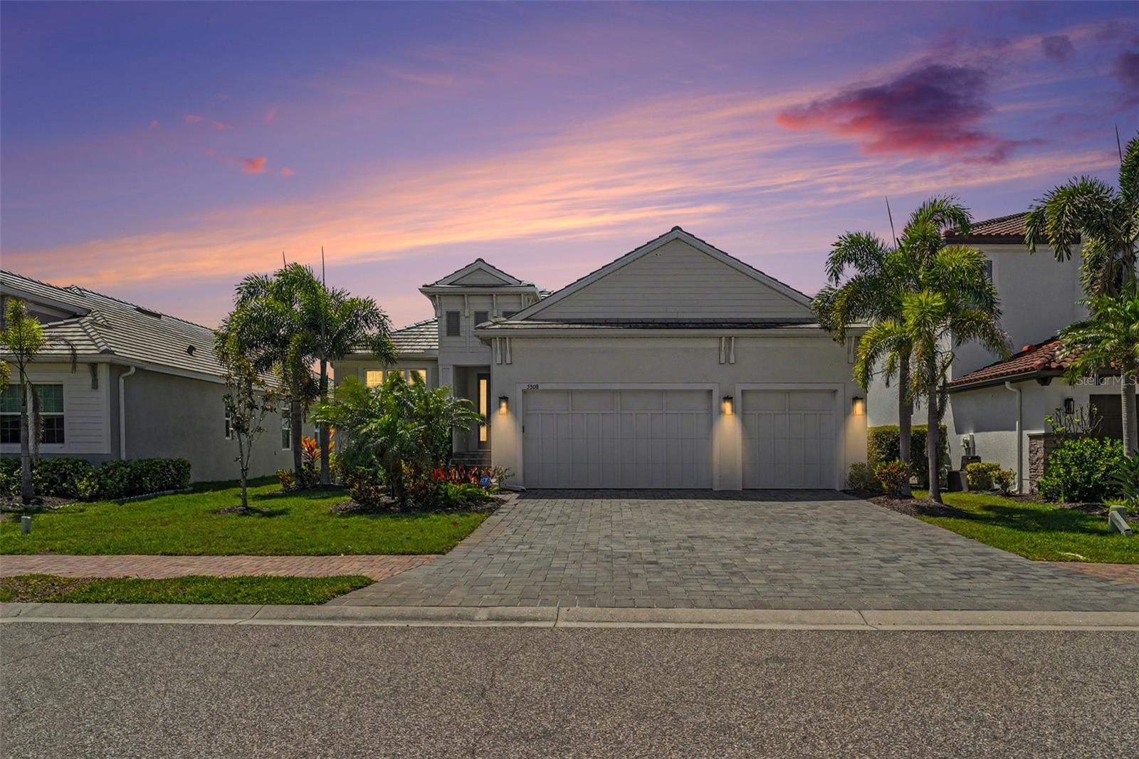 Indulge in elevated coastal living, set within the exclusive, double-gated enclave of Legends Bay. Built in 2019, this refined residence blends modern elegance with effortless indoor-outdoor living, creating a sanctuary of sophistication and ease. Inside, nearly 2,200 square feet unfold with soaring beamed ceilings and sunlit open spaces designed to inspire. The chef’s kitchen is a true showpiece, featuring premium built-in appliances, a gas cooktop, sleek cabinetry, and a striking designer island perfect for both intimate mornings and grand entertaining. The private primary suite offers a serene retreat, complete with a walk-in closet and a spa-inspired bath adorned with luxurious finishes and a frameless glass shower. Two additional bedrooms and a refined den or home office provide flexibility for work, relaxation, or hosting guests in style. Step outside to your own resort-inspired escape—an expansive screened lanai with a heated spa, surrounded by lush landscaping and tranquil privacy. Whether savoring sunset cocktails or hosting elegant alfresco gatherings, this outdoor haven captures the essence of Florida luxury. A spacious three-car garage adds both convenience and prestige. Beyond the home, Legends Bay offers a lifestyle reserved for the discerning few. Enjoy private waterfront access via a scenic boardwalk leading to Sarasota Bay, a lakeside clubhouse, and a stunning infinity-edge pool. Perfectly positioned just minutes from IMG Academy, IMG Golf & Country Club, the boutiques of St. Armand's Circle, the pristine beaches of Anna Maria Island, and the vibrant culture of downtown Sarasota, this location is as exceptional as the home itself. This is more than a residence—it’s a statement of elegance, privacy, and coastal sophistication.