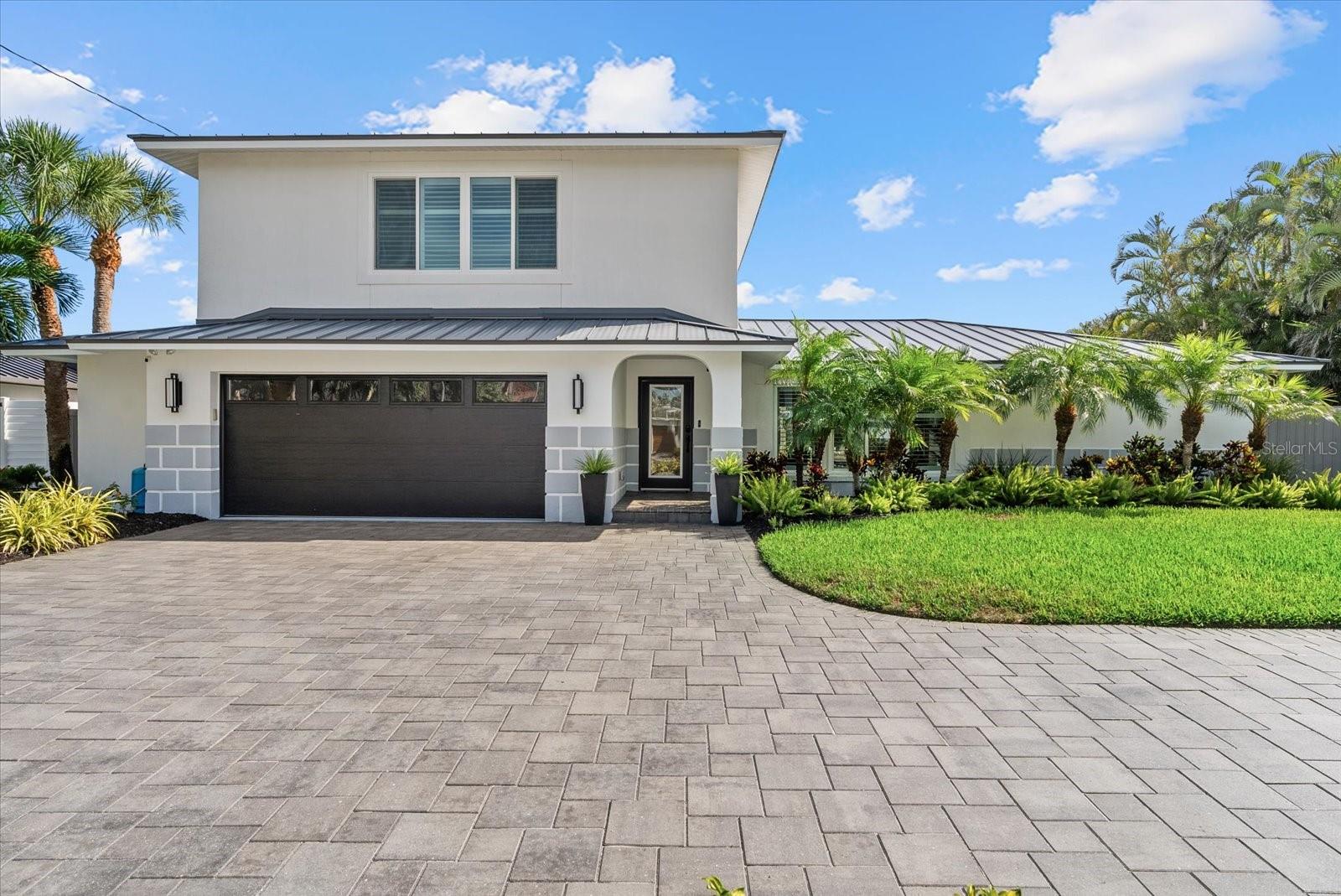 Tucked away near the end of a quiet cul-de-sac on an oversized, private waterfront lot in Siesta Isles with 109 feet of frontage on Siesta Key's Grand Canal, this exceptional 4,161-square-foot residence offers a rare combination of privacy, expansive living spaces, extensive upgrades, and breathtaking water views. Positioned at the canal's coveted "Big Bend," the home enjoys panoramic open-water vistas enhanced by neighboring county-owned green space, creating a lush natural backdrop and a remarkable sense of seclusion. Designed for both grand entertaining and everyday comfort, the light-filled floor plan features four bedrooms+bonus room, three full baths, multiple living areas, and rich wood flooring throughout.  At the heart of the home is a gourmet chef's kitchen appointed with premium appliances, seamlessly connecting to an expansive great room where floor-to-ceiling glass frames stunning waterfront views.  A separate entertaining bar features illuminated cabinetry, a wine refrigerator, sink, second Bosch dishwasher, and pass-through window to the lanai, making indoor-outdoor hosting effortless.  The great room easily accommodates a dining table for ten while offering multiple gathering spaces to relax and enjoy the ever-changing waterfront scenery. The spacious primary suite serves as a private retreat, featuring a newly replaced waterfront deck and captivating water views from nearly every angle. Extensively upgraded with an emphasis on durability and peace of mind, the home features impact-rated windows and doors, recently replaced metal and flat roofs, two elevated HVAC systems, an elevated whole-house generator, mini-split air conditioning in the garage, two water heaters, extensive electrical upgrades, and all cast-iron sewer lines replaced with PVC.  Outside, the resort-style living experience continues with expansive travertine patios, a heated saltwater pool and spa, multiple covered and open-air seating areas, and exceptional boating amenities including a new dock, 10,000-pound boat lift, and additional double jet ski/kayak lift. Professionally designed landscaping and architectural lighting enhance the home's tropical setting, creating a beautiful ambiance both day and night. With quick access to Roberts Bay and the Intracoastal Waterway, this property is perfectly suited for boating enthusiasts. Located just one mile from world-famous Siesta Key Beach and minutes from Sarasota's renowned dining, shopping, and cultural attractions, this extraordinary waterfront retreat offers the perfect blend of luxury, comfort, boating lifestyle, and privacy.  This is truly A HOME FOR JOYFUL GATHERINGS!