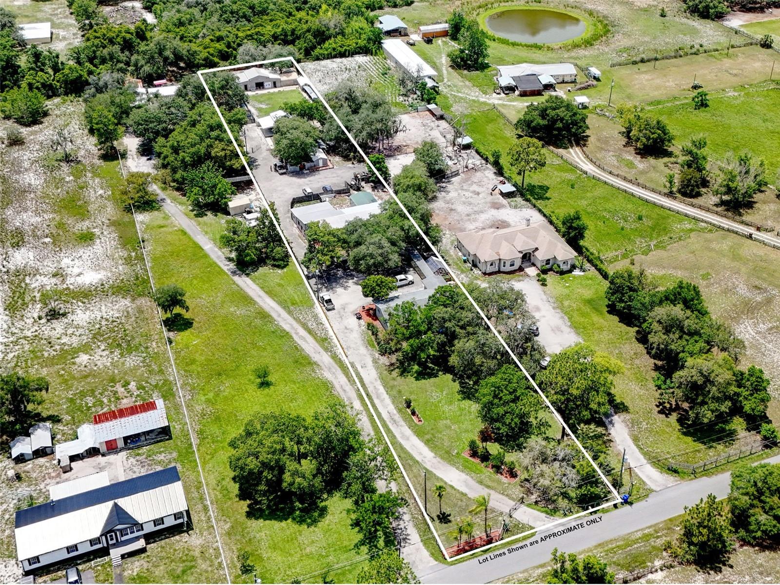 Once-in-a-lifetime private compound opportunity in Chuluota, less than a mile from Lake Mills Park! Situated on 1.39 acres, gated and fully fenced with no HOA and A-5 zoning allowing for horses and/or livestock, this rare property offers 7 bedrooms, 5 bathrooms, 5,432 total living square feet, four separate living quarters, multiple permitted buildings, income potential, and a level of flexibility that almost never comes available for purchase in this area! 
The main residence was built in 1971 and features 3 bedrooms and 2 bathrooms, with appliances installed in 2025, flooring installed in 2023 and 2024, a bathtub replaced in 2025, a new 2025 water heater, almost all windows replaced between 2020 and 2022, a 2015 roof, generator hookup, 2025/2026 paint, 2026 landscaping, and 2026 fence rehab and treatment. Connected to the main house by a long covered walkway is a separate building that includes two additional private living quarters with their own separate entrances and no interior access between them. One side offers a huge living area, 2 bedrooms, 1 bathroom, and a full kitchen, creating an ideal guest house, man cave, in-law suite, adult-child setup, or income-producing opportunity. The other side offers a private 1 bedroom, 1 bathroom living space with a kitchen and its own screened porch.
A fourth private living quarter is located in another detached building and includes a bedroom and bathroom, with the bathroom certified as a business bathroom and handicap accessible. This space does not include a full kitchen, but adds even more flexibility for extended family, guests, office use, studio space, or other creative needs.
Beyond the living quarters, the property includes a permitted 2024 building of approximately 450 square feet with a roll-up door and high ceilings, making it perfect for boat parking, equipment, storage, workshop space, or future possibilities. Toward the rear of the property is another large building, constructed and permitted in 2017, currently used as office, workshop, and utility space. For the savvy business owner who wants office or work space right outside the front door, this setup is incredibly compelling.
The property is supported by 3 septic tanks, 1 well, and 3 electric meters, giving the compound-style layout practical infrastructure to match its rare flexibility. Whether you are looking for a multi-generational family estate, a private rural retreat, income potential, space for horses or livestock, room for boats and equipment, or simply a property with separation, privacy, and options, this one stands apart.
Located about one mile from Lake Mills Park, a 50-acre Seminole County park with free public access, a public boat launch, fishing pier, picnic pavilions, playground, campground, and recreational access to Lake Mills. Enjoy a peaceful Chuluota setting while still being near Oviedo, UCF, major roadways, shopping, dining, and highly regarded Seminole County schools including Walker Elementary, Lawton Chiles Middle, and Hagerty High School.
Properties like this rarely come available. Four private living quarters, 1.39 acres, no HOA, A-5 zoning, multiple outbuildings, income potential, business/workshop flexibility, and proximity to Lake Mills Park all combine to create a truly unique opportunity.