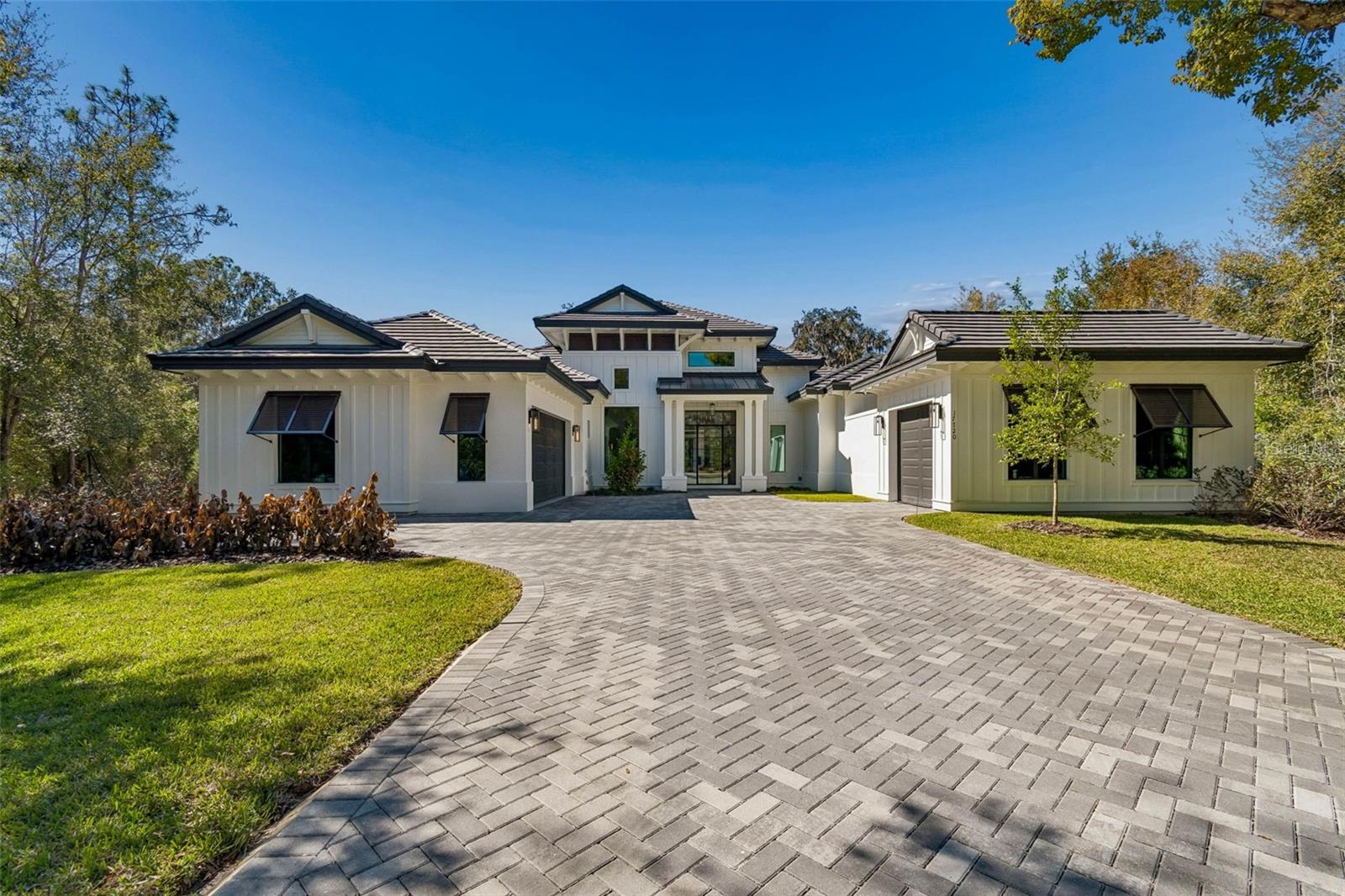 One or more photo(s) has been virtually staged. Welcome to this newly built, custom-designed 4-bedroom, 4.5-bath luxury pool home located in the prestigious gated community of Liberty Oaks. Crafted with exceptional attention to detail and timeless design, this residence offers a seamless blend of sophistication, comfort, and modern convenience. From the moment you enter the private gates of Liberty Oaks, you’re surrounded by stunning architectural elegance. This Arthur Rutenberg masterpiece showcases impeccable craftsmanship, from the beautifully designed driveway and grand entryway to the soft-toned hardwood floors and striking quartz surfaces throughout the home. The thoughtfully designed open floor plan features soaring ceilings accented with custom beams, creating an airy and refined atmosphere. At the heart of the home is a chef’s dream kitchen outfitted with a premium Thermador appliance package, custom soft-close wood cabinetry, and two expansive waterfall-edge islands—perfect for gathering and entertaining. A hidden walk-in pantry provides abundant storage while maintaining the home’s clean, elegant aesthetic. The kitchen flows effortlessly into the spacious family room, where wood-beamed ceilings and panoramic views of the pool create a warm yet elevated living space. The luxurious primary suite offers a true private retreat with direct access to the pool and courtyard, dual walk-in closets, and a spa-inspired bath featuring a freestanding soaking tub, an oversized walk-in shower with four showerheads, dual quartz vanities, and a private water closet. Each of the three additional bedrooms includes its own en-suite bath and walk-in closet, providing privacy and comfort for family and guests alike. A bright, front-facing office with expansive windows and soaring ceilings offers the perfect work-from-home environment. A secondary private entrance enhances the home’s versatility, ideal for guests or multigenerational living. Step outside to your resort-style outdoor oasis. Impact sliding glass doors open to a heated saltwater pool with a spillover spa, now enhanced with a full screen enclosure (pool cage) for year-round enjoyment and comfort. The covered outdoor kitchen and expansive lounge area make entertaining effortless. Just off the pool deck, a 677-square-foot detached casita provides the perfect in-law suite, guest retreat, or private studio space. For added security and peace of mind, the sellers have installed a gas-operated whole-home generator, ensuring uninterrupted power and convenience during any weather conditions. Liberty Oaks is an exclusive enclave of luxury residences located just north of Downtown Tampa, offering convenient access to premier hospitals, upscale shopping, fine dining, and Tampa International Airport. This is more than a home—it’s a statement of elevated living, where luxury, function, and thoughtful upgrades come together in perfect harmony.