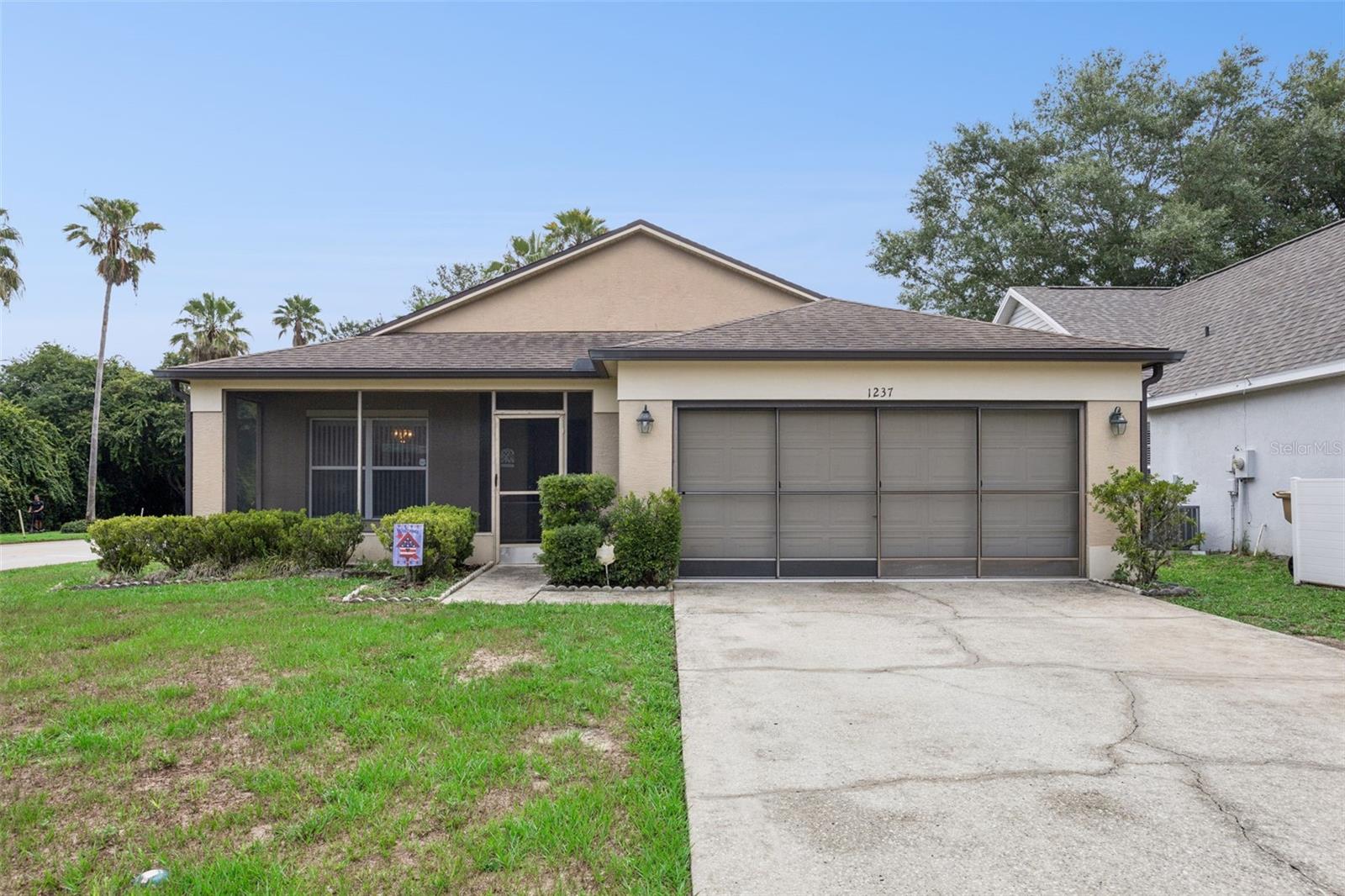 Welcome home!! This is a beautifully maintained property in Clermont, perfectly situated on a spacious corner lot in an outstanding Central Florida location. Thoughtfully designed with comfortable living spaces, a functional floor plan, and inviting indoor and outdoor areas, this home offers everything you need to enjoy the Florida lifestyle. From the moment you arrive, the expansive driveway and charming screened front porch create a welcoming first impression, providing the perfect place to enjoy your morning coffee or greet family and friends. Step inside to discover an inviting interior where entertaining feels effortless. A formal dining room is conveniently positioned near the entrance and flows directly into the kitchen, creating an ideal setting for holiday gatherings, dinner parties, and everyday meals. The generously sized living room features soaring ceilings that enhance the open feel of the home while providing plenty of room to relax, entertain, or spend quality time together. The kitchen is designed with both function and convenience in mind, with abundant workspace, ample cabinetry, and a cozy dinette that's perfect for casual breakfasts, after-school snacks, or morning coffee before the day begins. The split-bedroom layout provides added privacy for everyone, with the spacious primary suite tucked away on its own side of the home. Complete with a large walk-in closet and a private en suite bathroom featuring dual vanities that make busy mornings effortless, this suite is sure to become your own personal retreat. The secondary bedrooms are comfortably sized and filled with natural light, providing  flexibility for family members, overnight guests, or even a hobby room to fit your lifestyle. Step outside to enjoy the screened rear patio, where you can unwind in the fresh Florida air, dine outdoors, or simply relax while enjoying the comfort of a bug-free outdoor living space throughout the year. Ideally located in Clermont, this home places you just minutes from major highways, highly rated schools, shopping centers, restaurants, and everyday conveniences. World-famous attractions, including Walt Disney World, are less than 20 minutes away, making it easy to experience the very best of everything Central Florida has to offer. Don't miss your opportunity to make this wonderful home your own, schedule your private showing TODAY!!!
