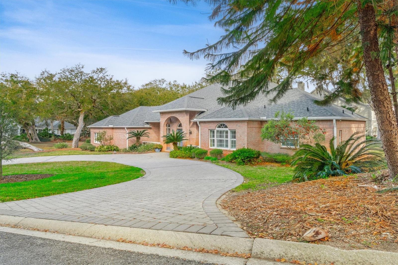 One or more photo(s) has been virtually staged. Rare. Private. Irreplaceable. Nestled on an expansive, park-like lot beneath a cathedral canopy of mature live oaks, this all-sided brick estate is the kind of property that simply doesn't come to market twice. Set within a private gated enclave just minutes from St. Augustine's world-famous beaches, 125 Island Hammock Way delivers the best of Florida living — serene natural surroundings, walkable community charm, and sophisticated custom craftsmanship — all under one roof. Built for those who refuse to compromise, this single-story custom residence spans 3,113 square feet of thoughtfully designed living space, offering 3 bedrooms, 2½ baths, and a private den. Four-sided solid brick construction means enduring curb appeal and low-maintenance ownership — a distinction rare even in luxury communities.
Inside, 10-foot ceilings, rich hardwood floors, and elegant crown molding set an immediate tone of refined elegance. The expansive living room anchors the home with a wood-burning fireplace, custom built-in cabinetry, and French doors that open seamlessly to the screened patio — blurring the line between indoor comfort and the lush outdoors. At the heart of it all, the gourmet kitchen is a chef's dream: five-burner gas cooktop with automatic exhaust fan, built-in wall oven and microwave, granite countertops, a center island, and walk-in pantry — designed as much for Sunday morning pancakes as for Saturday dinner parties. The primary suite is a genuine retreat — vaulted ceilings, two generous walk-in closets, and a spa-inspired bath featuring dual vanities, a spacious roll-in shower with dual heads, built-in bench seating, and custom niches. A separate den with French doors offers flexibility as a home office, library, or media room. Step outside and the lot tells its own story. The covered, screened tiled patio opens to generous grounds that feel more like a nature preserve than a backyard — a true rarity in Northeast Florida. A paver driveway with an additional circular front drive offers impressive arrival and ample parking, while the oversized two-car garage features epoxy flooring, storage cabinets, ceiling fans, and pull-down attic access. The community itself is one of Island Hammock's understated pleasures — a walkable, peaceful enclave where neighbors stroll beneath the oaks and everyday life feels unhurried. And when the mood strikes, the beach is just minutes away, alongside St. Augustine's vibrant dining, boutique shopping, and historic downtown.
This is not just a home. It's a lifestyle that's nearly impossible to replicate. Schedule your private showing today.