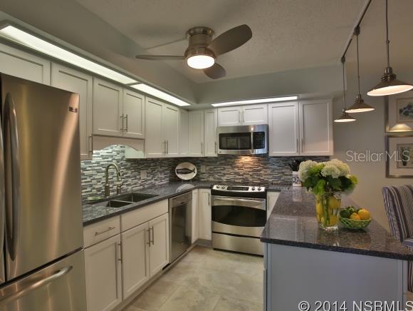 RARE BEACHSIDE FIND in a well established small community where available units in original condition sell quickly and are in demand!  This 2BR 2.5 BR beach house with one of the few larger avail hardscape very private patio nestled in a vibrant part of the hardwood canopy," right across the street to the stunning no drive beach"This unit has been beautifully renovated from top to bottom with gorgeous top of the line materials and fittings and is a MUST SEE.  18" x 18" travertine flooring throughout the main floor and all bathrooms, quality Shaw carpet upstairs.  Large patio second floor is accessible from both good size bedrooms. Beach white cabinet kitchen with polished natural stone countertops and pencil glass and carerra marble tile backsplash and deep dual sink. Nice dining space. Four excellent SS appliances with extended warranty. New central aircon unit winter 2013, new dryer Dec 2013, upgraded electrical and so much more.Lovely new aluminum sunroom off the kitchen and living area . Four new double top of the line PGT Winguard impact resistant UV filtering patio sliders which qualify for insurance premium reduction.  All bathrooms have a real "wow" factor and feature beautiful custom all hardwood free standing white vanities with luxury sinks and quartz vanity tops , designer tile finishings, lighting, mirrors and bath fixtures. Soaker size tub and rain head shower in the 2nd bathroom beautiful rain head and wand walk in shower in the master ensuite, dual sinks. Perfect soft beach colors throughout for that truly classy beach house feel. Pool, tennis and shuffleboard very good fees for the beachside.Don't miss this one. This is not a paint only " upgraded" unit. It's quality renovated priced well for the many features ,beautiful and move in ready. Beach house away from home or luxury rental? Perfect either way! ;Water: City