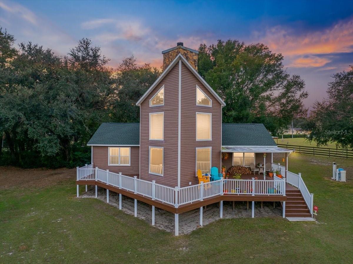 Get ready to fall in love with this custom-built retreat set on 6.13 fully fenced acres in Dover, where privacy, space, and flexibility create an exceptional living experience. A private gated entrance welcomes you down the drive, setting the tone for peaceful country living—while still being just minutes from shopping and offering easy access to both Tampa and Orlando. Designed for freedom and versatility, this no HOA, no CDD property is zoned ASC-1, allowing farm animals and a wide range of uses. Whether you envision a hobby farm, workshop space, recreational escape, or simply room to spread out and enjoy the outdoors, this property delivers endless opportunity. Recent upgrades add value and peace of mind, including new coils on both AC units, a new roof installed in October 2025, and a new water heater added in November 2025. The property is well-equipped with extensive storage and outbuildings, including a 3-car detached garage with air conditioning, full insulation, an icynene-insulated roof, and hurricane-grade doors, along with an additional 30x50 garage—both complete with water and electricity. With ample garage space and storage throughout the property, there’s plenty of room for RVs, boats, trailers, tools, and equipment. Outdoor living truly shines here. Relax on the welcoming Trex composite front porch, designed to withstand Florida’s climate while offering the perfect spot for morning coffee, and evening gatherings. Inside, the home opens to dramatic two-story cathedral ceilings accented by double-stacked tinted windows that flood the space with natural light. A striking stone wood-burning fireplace anchors the main living area, adding warmth and character. The kitchen and dining areas are thoughtfully designed for both daily living and entertaining, with seamless access to the outdoor deck for easy indoor-outdoor flow. Two spacious downstairs bedrooms each feature private en-suites and walk-in closets, ideal for guests or multi-generational living. The primary suite, privately located on the second level, offers a quiet retreat with high ceilings, a generous walk-in closet, and a spa-inspired bathroom with a soaking tub and separate shower. This property offers a rare balance of acreage, privacy, functionality, and convenience, creating a lifestyle that’s both practical and inspiring.