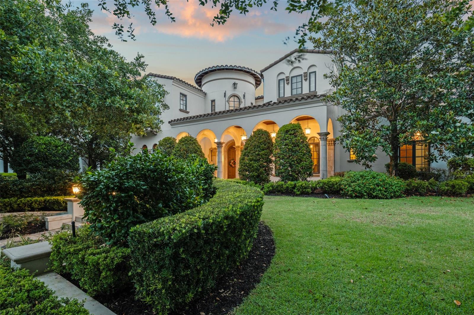 Welcome Home to a One-of-a-Kind Estate on Coveted New Broad Street in Baldwin Park Situated on a prime corner lot in the heart of Baldwin Park, this extraordinary estate was masterfully built by renowned custom homebuilders Goehring & Morgan as the official 2007 International Builder’s Show Home. Blending Old World Mediterranean elegance with cutting-edge technology and unrivaled craftsmanship, this home redefines luxury living.From the moment you step through the hand-carved entry door, you’re welcomed by an exquisite circular foyer with inlaid marble and travertine flooring, soaring coffered, barrel-vaulted, and beamed ceilings, intricate moldings, and solid custom doors. Smart home integration allows for seamless control of lighting, and has the capability of adding audio/visual, HVAC, and security systems with the touch of a button. Designed for both grand-scale entertaining and intimate everyday living, the chef’s kitchen is equipped with premium appliances including an 8-burner gas range, custom stone hood, dual stainless steel refrigerators and dishwashers, double ovens, trash compactor, and an oversized 13-foot island. A bi-level wet bar and butler’s pantry with its own fridge and ice maker complete the entertainer’s dream layout. The first-floor master retreat is a private sanctuary, featuring a cozy sitting area with a built-in coffee bar, direct access to the veranda, a gas fireplace, fireside soaking tub, and a spa-like shower. The custom walk-in closet includes a ladder-accessible second level for ample storage. Also on the first floor: a library, wine cellar with tasting bar, mudroom, and a private guest suite. Upstairs, you'll find three additional bedrooms, a craft room, and a state-of-the-art media/game room with walnut floors and a full snack bar (microwave, fridge, sink, and ice maker). Motorized blinds, integrated lighting, and audio/video systems ensure an immersive entertainment experience. Step outside to a breathtaking outdoor living space with Cypress coffered ceilings, a fireplace, a summer kitchen, flat-screen TV, and multiple seating areas—all overlooking the travertine-paved pool deck, reflection tile spa, and trellis-covered waterfall framed by lush, private landscaping. Additional highlights include a fully equipped garage studio apartment with a private entrance that’s ideal for guests or potential rental income, a large house generator, a spacious three-car garage, and a recently updated tile roof installed in 2021. This home also features a significant collection of custom-made Ethan Allen furniture, thoughtfully selected to complement each room; these high-quality pieces may be included in the sale. Truly one of Baldwin Park’s most iconic homes, this residence offers an unparalleled combination of luxury, privacy, and modern convenience. Schedule your private showing today and experience craftsmanship and elegance at its finest.