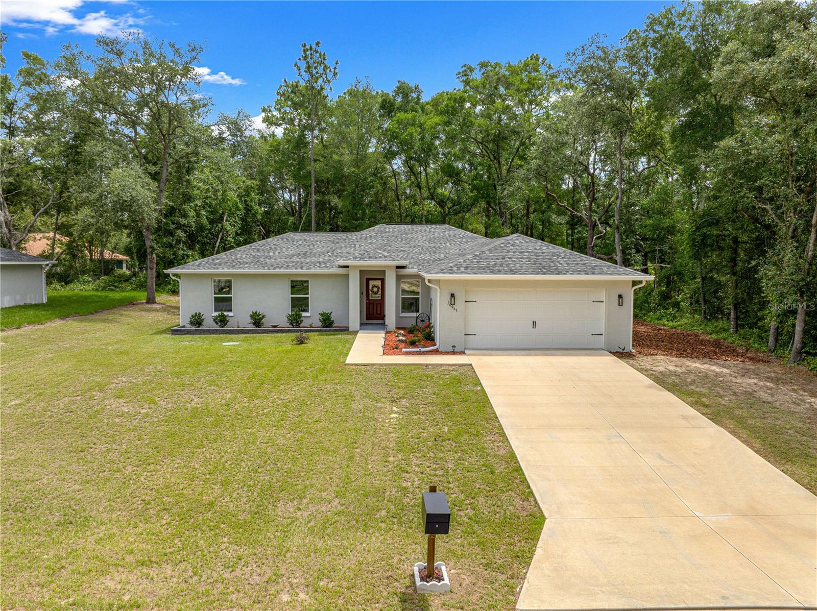Surrounded by nature and thoughtfully upgraded throughout, great for those who love outdoors as its just a mile away from the Withlacoochee state trail, 2.9 miles from trail head or you can access with a bike by crossing Hwy 41m this beautiful 2024 built home sits on just over a quarter-acre lot with wooded views behind and to the right, creating a peaceful setting where birds and native wildlife are frequent visitors. Outstanding curb appeal includes stacked-stone landscape curbing, gutters and down spouts, and an elegant leaded-glass entry door. Inside, soaring vaulted ceilings and luxury vinyl plank flooring flow throughout the home. The spacious great room opens through sliding glass doors to the screened Lanai, creating seamless indoor-outdoor living. The kitchen features granite countertops, stainless steel appliances, 42-inch upper cabinets, a pantry closet, and an open design that connects effortlessly to the dining area and great room. The primary suite offers private Lanai access, a walk-in closet, dual granite-topped vanities, and a tiled walk-in shower with a built-in corner seat. Three additional guest bedrooms provide flexibility for family, guests, or a home office. The guest bath includes a deep soaking tub with tile surround and exterior access, making it ideal for a future pool. Outdoor living is highlighted by a large screened Lanai and open-air patio overlooking the natural wooded backdrop—perfect for morning coffee, evening relaxation, or entertaining friends and family. Additional Features: Well-organized laundry room • Hall linen closet • Generator electrical hookup in garage • Transferable 10-year structural warranty • Transferable termite bond • Transferable HVAC maintenance agreement