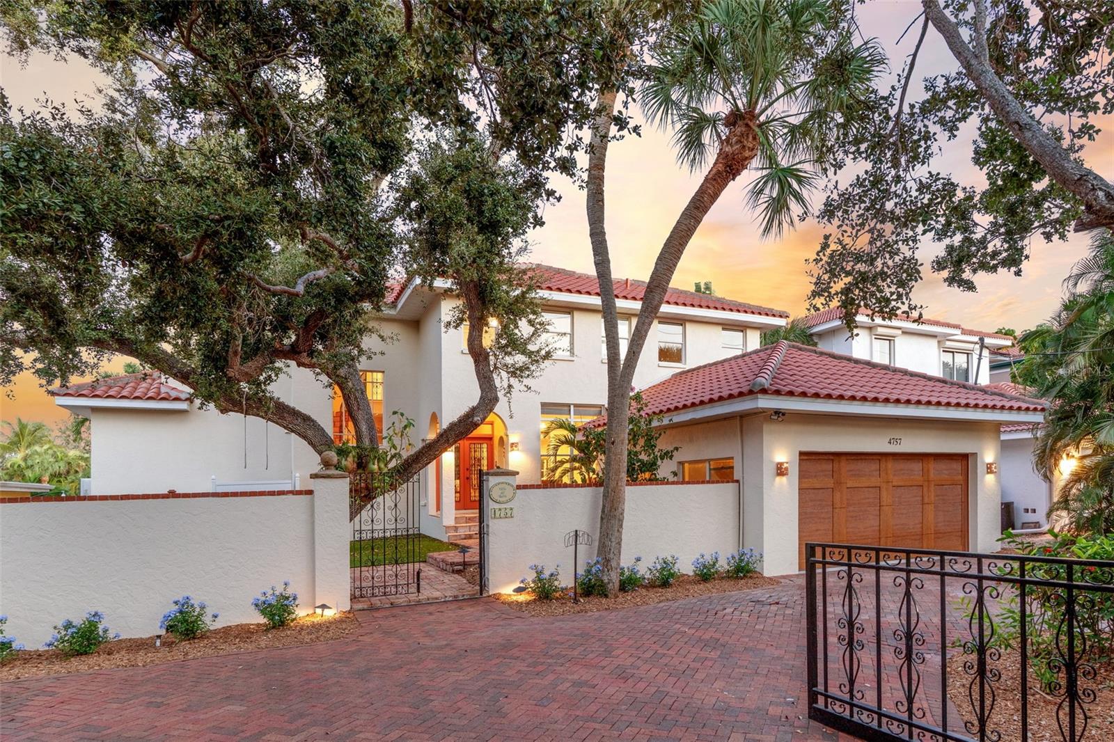 Welcome to “Villa del Roble” (Oak Villa) on Siesta Key’s Grand Canal—a true boater’s dream and an elevated waterfront residence that remained free of flooding during recent hurricanes. Timeless elegance and refined sophistication hallmark this thoughtfully remodeled home, beautifully preserving its authentic old world charm and offering 3,200+ square feet on two floors, including four bedrooms, an office, and three full and one-half baths. A masterpiece of craftmanship, this light-filled home showcases soaring ceilings, walls of windows, and expansive outdoor living spaces.  And with over 70 feet of water frontage on the coveted Grand Canal, a 10,000-lb lift, two davits, and a Trex dock, the property provides effortless boating access directly from your backyard. Enjoy the heated pool and spa, intimate al fresco dining, a charming Tiki Hut, and a serene courtyard anchored by the majestic oak tree that inspired the home’s name. The remodeled kitchen shines with Sub-Zero and Thermador appliances, a gas cooktop, pendant lighting, stone countertops, and a well-appointed pantry – ideal for any culinary enthusiast. The sunroom, filled with natural light, has a convenient wet bar and offers peaceful canal views. The elevated main-level primary suite includes private outdoor access, a generous walk-in closet, and a spa-inspired bathroom with dual vanities, a soaking tub, and a walk-in shower. A dedicated office and powder bath complete the main floor, while three additional bedrooms (one that could serve as a secondary primary) and two full bathrooms upstairs provide ideal accommodations for family and guests. Conveniently located near Out-of-Door Academy and minutes from Siesta Key Beach, Siesta Key Village, and Sarasota’s world-class dining and shopping, this home combines exceptional boating amenities, elevated construction, and refined coastal living in one of Sarasota’s most coveted waterfront settings.