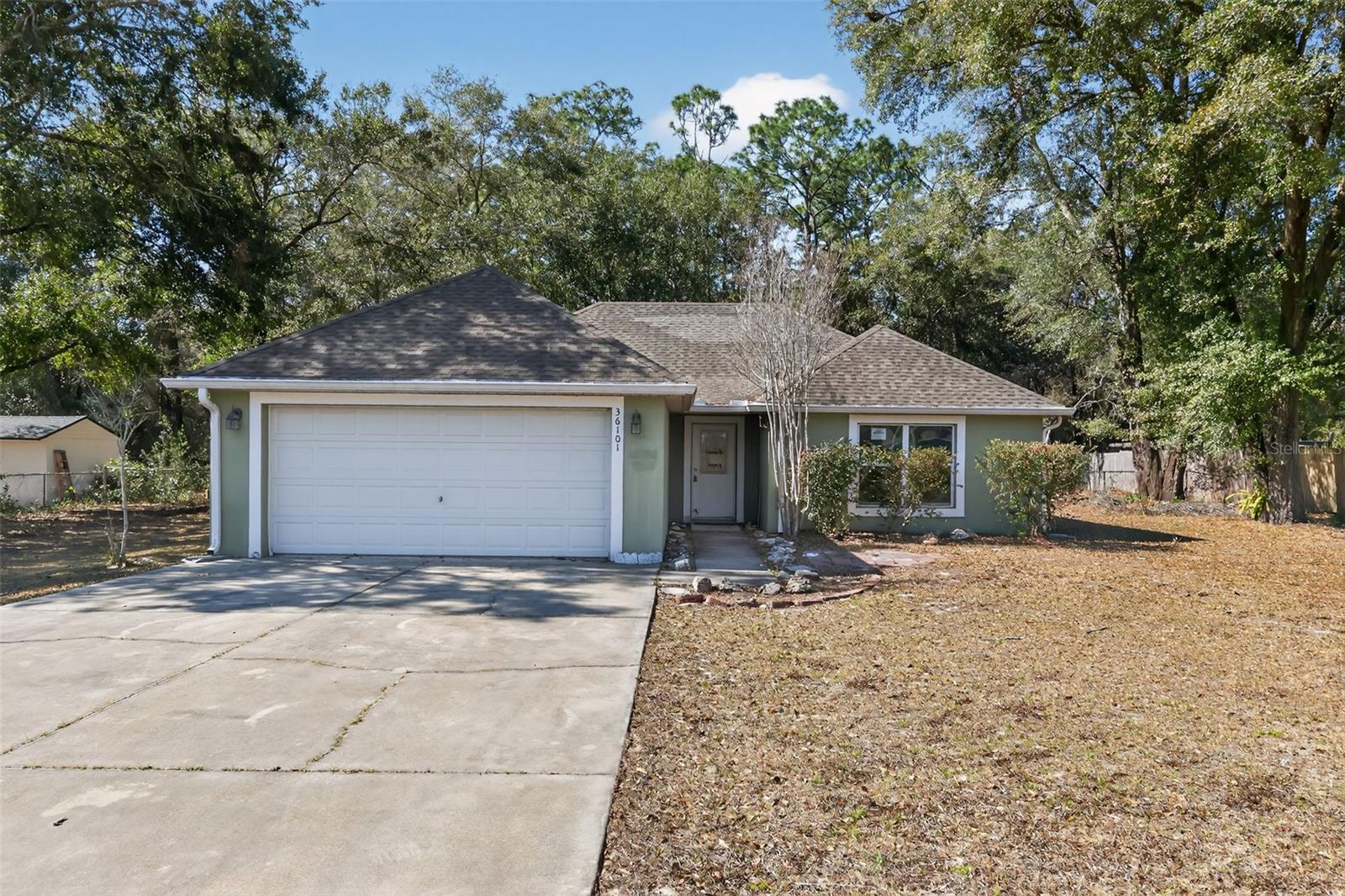 Tucked away on a quiet street in Eustis, this single-story home sits on a generously sized, tree-shaded lot offering privacy, space, and plenty of potential. Mature trees surround the property, creating a peaceful setting and a natural backdrop rarely found at this price point.

Inside, the home features a spacious layout with vaulted ceilings in the main living area, providing an open feel and great natural light. Multiple living and dining spaces offer flexibility for everyday living or entertaining, while sliding glass doors lead to a screened porch overlooking the backyard — an ideal spot to enjoy the Florida breeze.

The primary bedroom includes an en-suite bath, and additional bedrooms are well-proportioned with ample closet space. A two-car garage and extended driveway add convenience, and the expansive backyard allows room for outdoor living, gardening, or future enhancements.

Located just minutes from downtown Eustis, Mount Dora, local parks, shopping, dining, and major roadways, this property offers easy access to everyday essentials while maintaining a quieter, residential feel. A great opportunity for buyers looking for space, character, and a location with long-term upside.