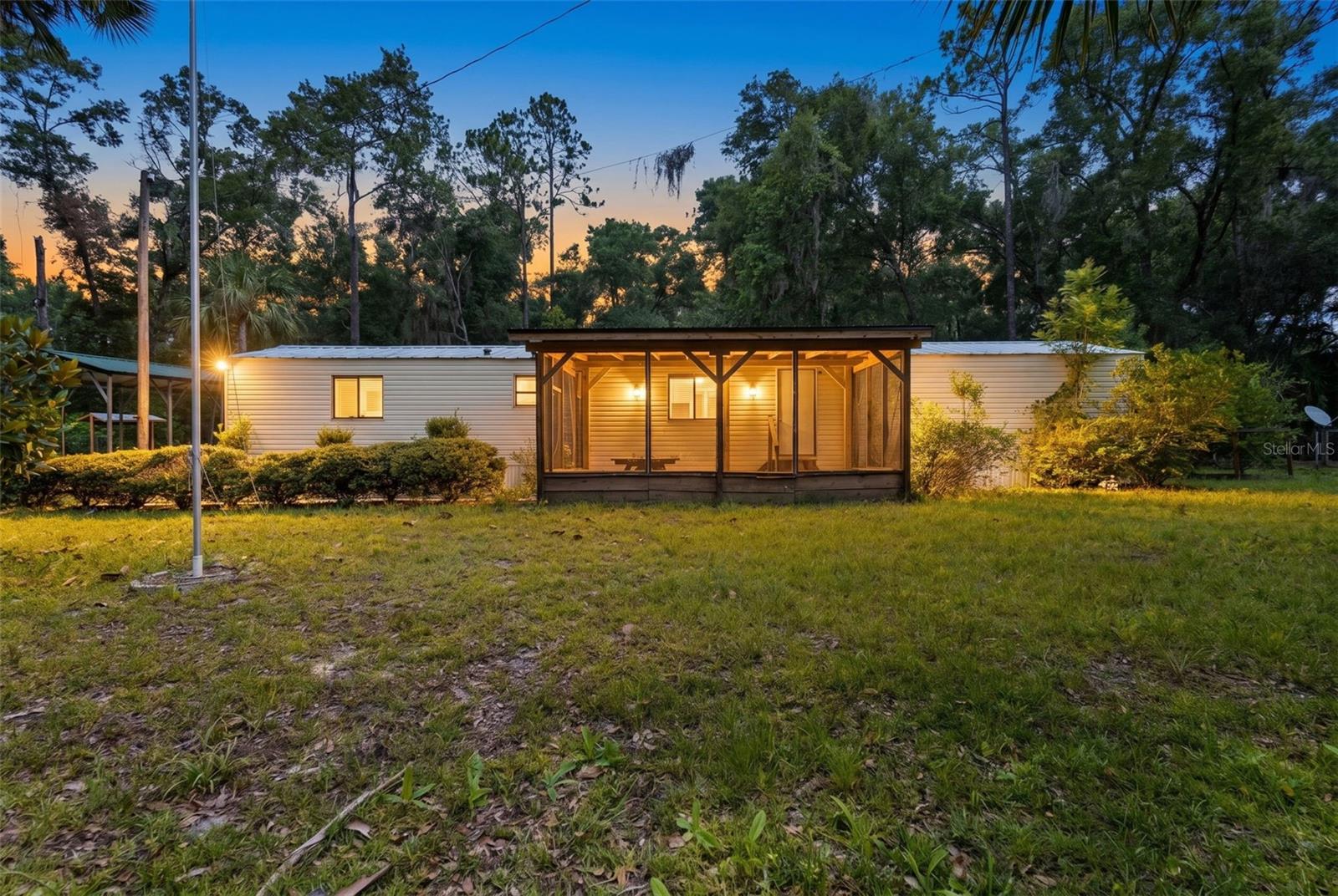 Tucked away on just over a quarter acre in Chiefland's Jemlands community, this 3-bedroom, 2-bathroom manufactured home offers a solid foundation for comfortable Florida living at an accessible price point. This home features 966 heated square feet with luxury vinyl and tile flooring throughout, and a layout that makes the most of the space.
The home comes equipped with a convection oven, refrigerator, dryer, and washer, and both bedrooms include built-in closets. Central air and heat keep things comfortable year-round, and the property runs on a private well and septic system with all utilities already connected.
Outside, you'll find a covered carport, a storage shed, and a screened outdoor entertaining space perfect for gatherings, weekend cookouts, or simply enjoying the natural surroundings. A front porch and rear porch round out the outdoor living options, giving you plenty of ways to take in the fresh Levy County air.
Located in Chiefland, you're just minutes from Fowler's Bluff on the Suwannee River, local dining and shopping along US 19/27, and within easy reach of Manatee Springs State Park, one of North Central Florida's most popular natural attractions. Crystal River is roughly 30 minutes south, and Gainesville is about an hour northeast, making this a convenient base for outdoor enthusiasts and those looking for a quieter pace without sacrificing access.