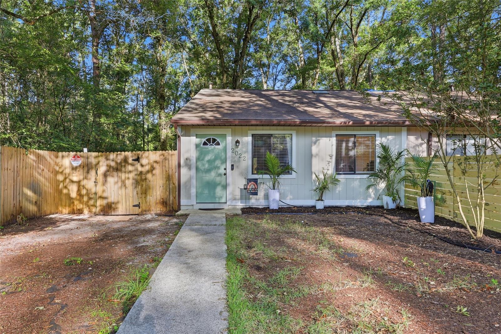 Welcome home to this nicely updated 3 bedroom, 2 bath home tucked away in southwest Gainesville with no HOA. From the moment you arrive, you’ll appreciate the fresh exterior paint, new front door, mature trees, and private fenced lot. Major updates provide peace of mind, including a new roof in 2020, HVAC system in 2022, and water heater in 2015. Step inside to a bright and inviting living room with vaulted ceilings, luxury vinyl plank flooring throughout, and plenty of natural light. The kitchen has been refreshed with white cabinetry, subway tile backsplash, updated countertops, stainless appliances, and ample workspace, creating a comfortable gathering space for everyday living. The split bedroom floor plan offers privacy and functionality. The primary suite features an updated en suite bath with dual vanities and generous closet space. Two additional bedrooms share an updated guest bath and provide flexibility for guests, family, or a home office. A spacious utility and laundry area adds extra storage and convenience. Out back, you’ll find a peaceful retreat shaded by mature trees. The fully fenced backyard features a large wood deck, charming pond feature, and storage shed, offering plenty of space to relax, garden, entertain, or enjoy the outdoors. Conveniently located near UF, North Florida Regional Medical Center, Celebration Pointe, shopping, restaurants, and I 75, this move in ready home offers thoughtful updates, a functional layout, and a private setting all with no HOA.
