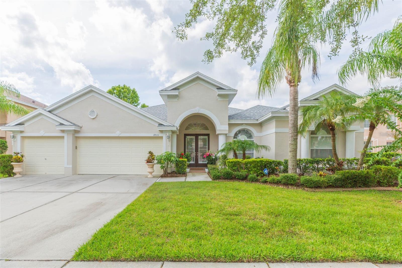 Under contract-accepting backup offers. Welcome to a truly exceptional residence in the sought-after Heritage Isles Golf & Country Club community, offering elegant design, thoughtful upgrades, and resort-style outdoor living overlooking the 4th fairway. This home was built for those who love to entertain and live beautifully. The formal double-door entry and decorative columns set the tone for the home's architectural grace. Step into a bright and expansive interior where soaring ceilings, warm teak flooring, and architectural arches invite you into the formal living and dining rooms, perfect for hosting elegant (or casual!) gatherings. The flow of natural light and the open layout create a vibrant and inviting atmosphere throughout. Office with french doors is located at the front of the home. The heart of the home is the impressively spacious great room, where multiple windows and French doors offer wide, uninterrupted views of the sparkling pool and lush golf course beyond. This gathering space easily accommodates seating for ten and includes a striking wet bar with decorative shelving, mirrors, long granite countertops, and a built-in beverage refrigerator. The chef’s kitchen is both functional and stylish, featuring French white raised-panel cabinetry, a contrasting island with bullnose granite countertops, a stainless farmhouse sink and a pot filler above the GAS stove. Buried propane tank provides the gas for cooking! You will also appreciate the newer appliances, the warming drawer, a French door refrigerator, and a breakfast nook with a corner window that provides a clear, relaxing view of the pool area. The spacious primary suite features a tray ceiling and French doors to the pool. The primary bathroom includes dual sinks, long vanities, a spa tub, large walk-in shower, and high-end fuxury fixtures. The split-bedroom floor plan offers privacy for guests and the third guest bedroom has easy access to the pool bath. Step outside to a travertine-tiled lanai that defines Florida living. The summer kitchen is equipped with a propane gas grill, large food prep station, and plenty of space for al fresco dining. The resort-style pool features multiple sparkling fountains, a zero-entry sun shelf, spa with spillover, and a tranquil waterfall feature. The pool is surrounded by multiple lounging areas, perfect for relaxing or hosting unforgettable gatherings. As a unique bonus, the screened area behind the home offers space for a practice chipping and putting green, ideal for sharpening your short game, especially with a serene golf course view as the backdrop. Laundry is near the kitchen and has newer appliances and storage. New roof (2024), New interior paint (2023), New AC units (2022 & 2021) and upgraded appliances and fixtures throughout. This northeast facing home is perfect for admiring the best sunsets in Florida where there is a kaleidoscope of colors in your back yard, a fountain for privacy while still enjoying the golf course view. Separate AC units for the home and the primary suite. Heritage Isles offers an 18-hole championship golf course, clubhouse with restaurant and activities, resort-style pool with Typhoon waterslide, fitness center, tennis and basketball courts and playgrounds. Conveniently located near I-75, top-rated schools, shopping, restaurants, and Flatwoods Park. Easy drive to Moffitt Cancer Center, University of South Florida, multiple hospitals, downtown and TIA. This is a lifestyle that will truly become your forever home. Love where you live!