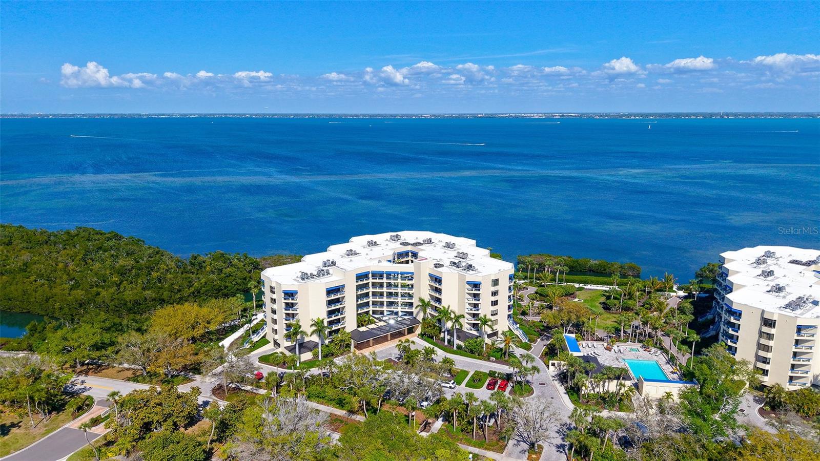 Step into coastal elegance in this fully renovated three-bedroom, two-bathroom Fairway Bay residence, where every detail has been thoughtfully reimagined. A charming private lanai and seating area welcome you before entering the unit, setting the tone for relaxed waterfront living. Inside, an open-concept layout seamlessly blends the kitchen, dining, and living spaces, creating a bright, airy environment perfect for both entertaining and everyday comfort. The gourmet kitchen is outfitted with GE Profile appliances, custom soft-close cabinetry, and ample storage, offering both style and functionality.  The primary suite is a serene retreat featuring a spacious walk-in closet, additional storage, and a beautifully updated en-suite bath with a large walk-in shower. From both the living room and the primary suite, step onto the expansive north-facing balcony to take in the tranquil Sarasota Bay views, where you can enjoy the morning sunrise and the soft glow of the evening sky.  The second bedroom is generously proportioned and easily accommodates a king-size bed, creating a luxurious space for guests. The third bedroom is also spacious, complete with a custom built-in, ideal for a guest room, home office, or flexible living area. A thoughtfully designed guest bath ensures privacy and convenience for family or visitors.  This unit also includes the ease and security of one covered parking space beneath the building. Fairway Bay residents enjoy an exceptional suite of amenities including two heated pools, a spa, a clubhouse, a fitness center, tennis and pickleball courts, and private beach access on Longboat Key. With the shops, dining, and vibrant lifestyle of St. Armands Circle just minutes away, this residence combines the best of convenience and refined waterfront living.