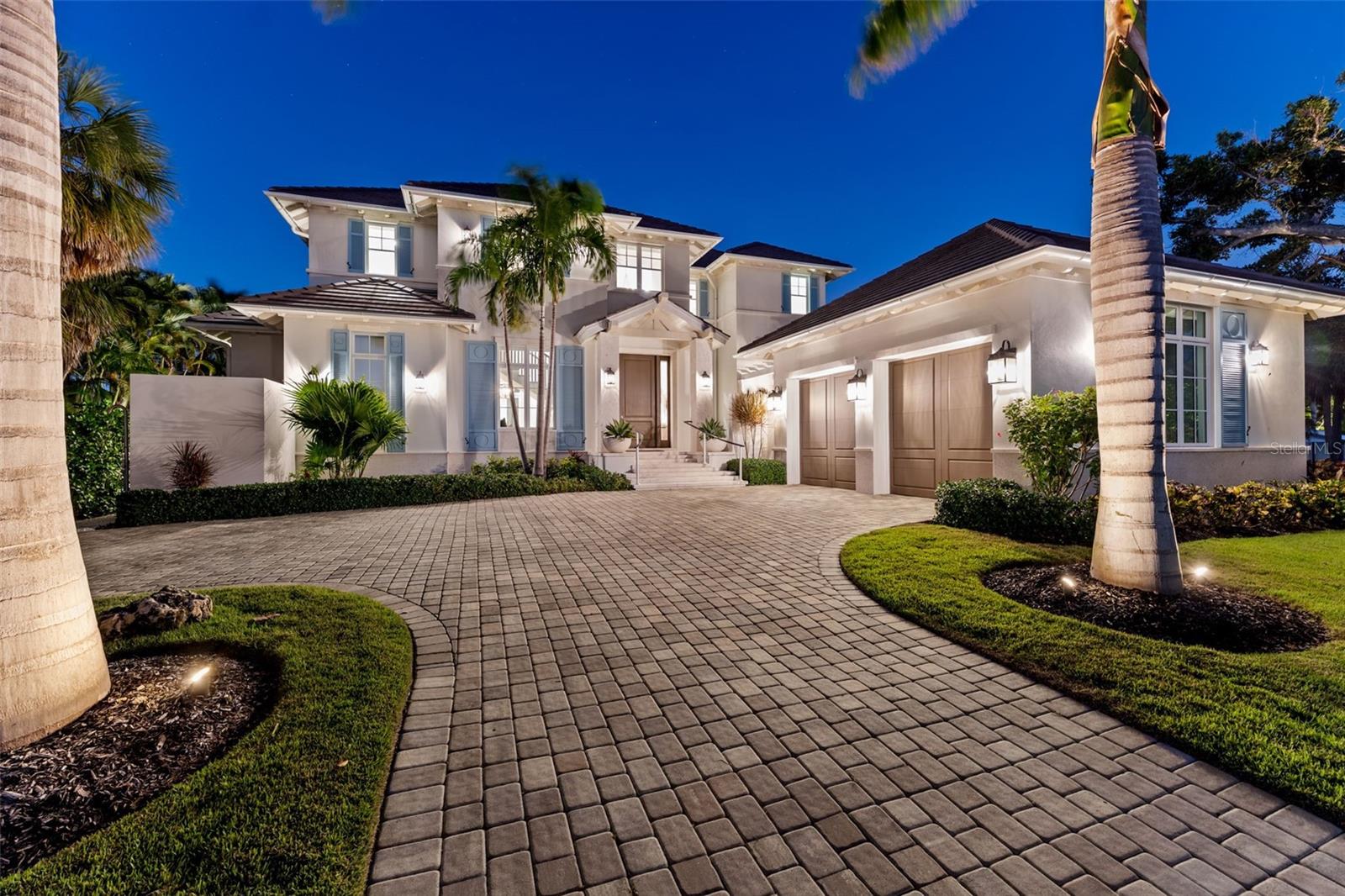 Longboat Key Waterfront Estate with Rare Beach and Boating Access. Designed by Stofft Cooney Architects and built in 2022 by Perrone Construction, one of the Gulf Coast’s premier luxury builders, this stunning coastal residence is a rare offering that blends modern design, structural integrity, and an exceptional location. Positioned on the desirable northern end of Longboat Key, the home offers a lifestyle few can match, with both deeded beach access directly across the street and canal frontage in the backyard. Where most homes require a choice between Gulf or Bay, this property offers the best of both. Step inside to discover a layout designed for both comfort and sophistication. The main level features a serene primary suite with a spa-inspired bathroom, a seated vanity, and a custom walk-in closet. A thoughtfully planned home office includes a custom built-in desk with dual workstations, offering dedicated space for both homeowners. The open-concept living area flows effortlessly into the designer kitchen, outfitted with quartz counters, Thermador appliances, a paneled refrigerator and freezer, wine fridge, and ice maker. A hidden walk-in pantry provides additional prep space and ample storage. Upstairs, a central family lounge connects three en-suite bedrooms, two with tranquil canal views where manatees are often spotted lingering at the water’s surface. The upper level is easily accessed by both a residential elevator and a beautifully crafted staircase with integrated storage. Every room has been carefully curated to reflect the home’s effortless luxury. For buyers seeking a fully realized, move-in-ready experience, furnishings can be negotiated separately. Outdoor living is elevated with a heated saltwater pool and spa, expansive lounging and dining terraces, and a fully equipped summer kitchen featuring stone counters, a Lynx grill, and built-in refrigeration, all protected by push-button retractable hurricane shutters. A dedicated pool bath adds convenience and keeps wet feet out of the house. The private dock includes a 16,000-pound boat lift, a 4,500-pound kayak or jet ski lift, plus additional space to dock a larger vessel in the water. The dock is fully outfitted with shore power, running water, integrated lighting, and a fish-cleaning station, ready for both adventure and convenience. Built high and dry, the home remained fully protected during recent storms, a true reflection of the enduring quality behind its construction. Combining beauty, function, and peace of mind, this is a rare opportunity to enjoy the very best of Longboat Key living, free from compromise.