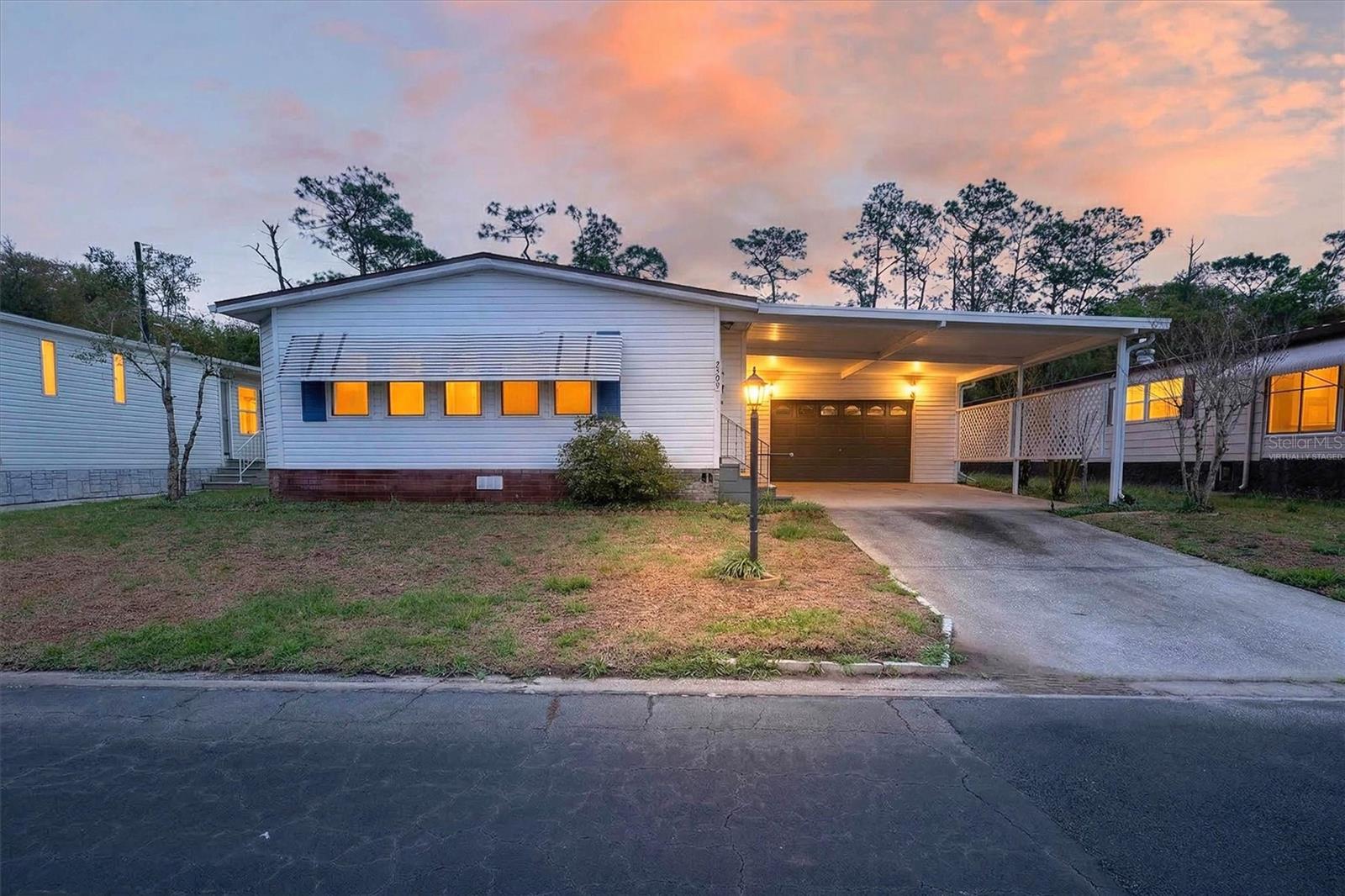 One or more photo(s) has been virtually staged. Priced $61,000 below recent appraisal! Nestled within the gated, 55+ community of Teka Village, this charming two-bedroom home features an extremely rare oversized two-car garage (19 x 36), plus a covered carport, an open living space, and a rear deck with a peaceful view, offering the perfect space for a relaxing living experience. The neighborhood encourages a leisurely pace of life where golf carts are permitted for convenient transportation, and residents can enjoy a variety of activities and events at the clubhouse. In addition, the indoor pool, fitness center, and shuffleboard courts support an active lifestyle and meaningful social connections with neighbors. Location-wise, you have exceptional access to a diverse set of dining, shopping, and recreation activities, along with quick access to the Turnpike. Golf enthusiasts will appreciate the proximity to Royal St. Cloud Golf Links, while nature lovers can enjoy nearby Peghorn Nature Park. Nearby Lakefront Park provides multiple shopping and dining options in tandem with its stunning waterfront views. Essential services reside close by, as well as additional shopping plazas for maximum convenience. The community and surrounding amenities cultivate an engaging lifestyle with events and facilities designed to bring residents together. Experience the calming nature of this wonderful home and community firsthand – schedule your private showing today. Roof 2018.