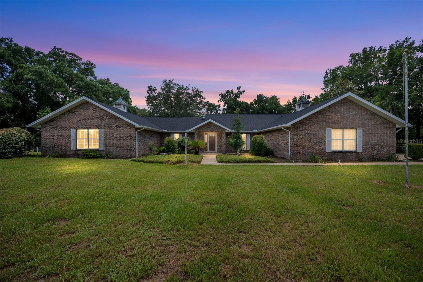 Experience the perfect blend of refined country living and equestrian charm in this beautifully 3-bedroom, 3-bathroom estate offering 2,632 square feet of living space on 3.01 picturesque acres in the highly desirable Countryside Farms of Ocala, a gated equine community.
A welcoming covered front porch invites you inside, where warm wood accents throughout the home create a timeless and inviting atmosphere. Designed for both comfortable living and entertaining, the home features a spacious formal dining room, a large living room, and a cozy family room centered around a wood-burning fireplace. The well-appointed kitchen overlooks the family room, making it the heart of the home and the perfect gathering place for family and friends.
The thoughtfully designed floor plan includes generously sized bedrooms, while the private primary suite offers dual closets and an en suite bathroom with dual vanities. An inside laundry room with a utility sink and built-in cabinetry adds convenience and extra storage.
Step outside to your own private oasis, where a screen-enclosed in-ground pool and expansive covered porch provide the ideal setting for entertaining or simply enjoying the peaceful surroundings. Beautiful mature trees frame the property, offering shade, privacy, and a picturesque setting.
Equestrian enthusiasts will appreciate the storage shed with horse barn features, providing flexibility for equipment, hobbies, or your equine needs. A two-car garage completes this exceptional property. 
Ideally located just 15 minutes from the World Equestrian Center, this property offers the best of both worlds—peaceful country living with convenient access to shopping, dining, hospitals, and all of Ocala's city amenities. With newly paved roads and no lease restrictions, this rare offering presents an outstanding opportunity for full-time residents, seasonal owners, or investment buyers.
If you've been searching for a private estate that combines spacious living, beautiful natural surroundings, and an exceptional equestrian lifestyle, this Countryside Farms of Ocala property is ready to welcome you home.