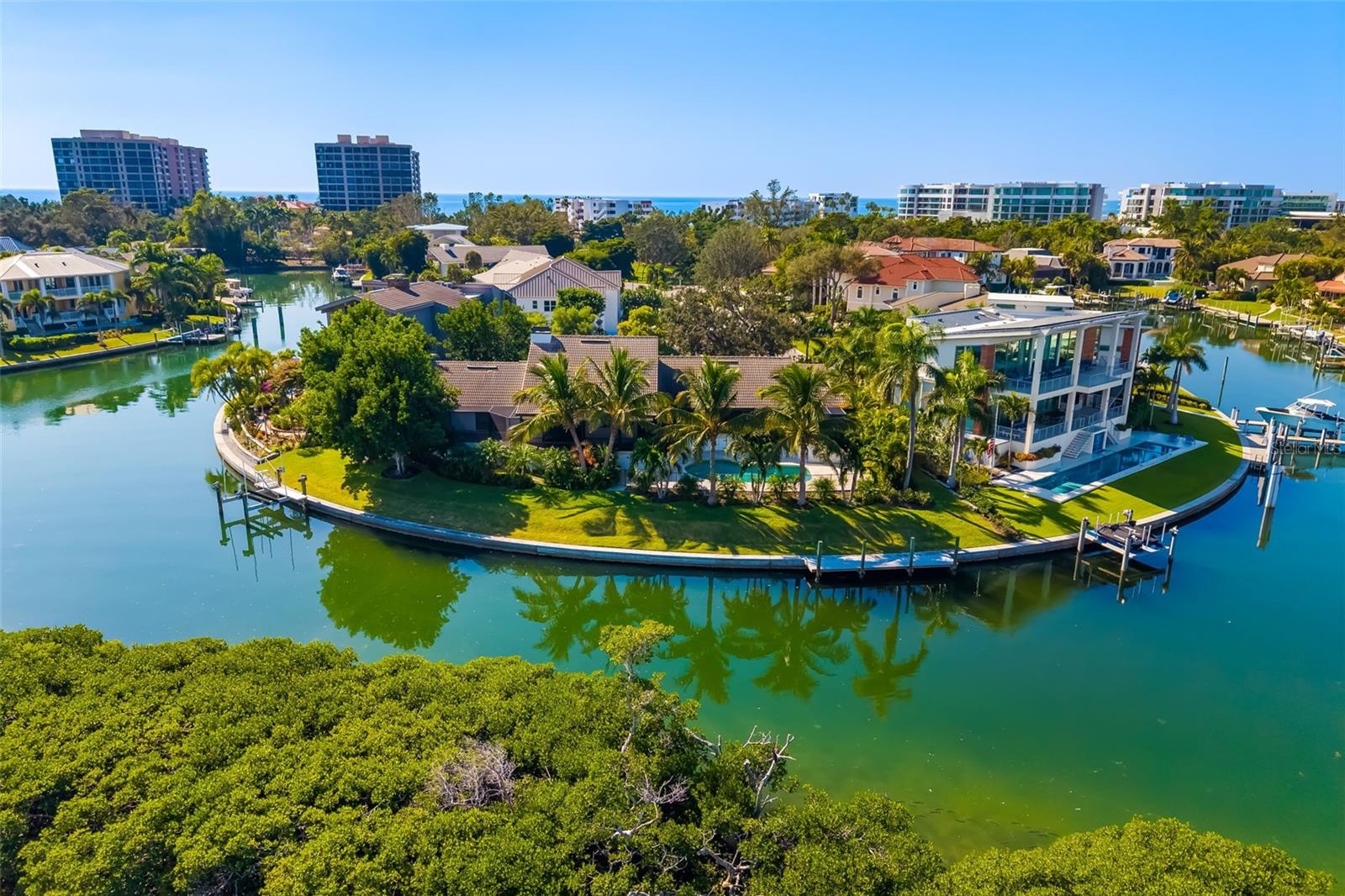 An exceedingly rare offering within the exclusive Bay Harbour enclave of Bay Isles on Longboat Key, this extraordinary peninsula estate delivers exceptional privacy, dramatic Sarasota Bay views, and direct boating access to both the Intracoastal Waterway and the Gulf of Mexico. Positioned at the end of a quiet cul-de-sac on a three-sided waterfront peninsula, the property features two private docks with water and electric, including one with a 15,000-lb lift designed for easy access. The Gulf is reachable through the nearby jetty with drawbridge, with an additional route via the John Ringling Bridge. The seawall was newly capped in 2020, and the pier deck and boat lift controls were replaced in 2025, ensuring superior waterfront infrastructure.
Extensively rebuilt and structurally engineered, the residence is warm, refined, and filled with natural light, capturing sweeping bay views from nearly every room. The chef-inspired kitchen showcases custom rare wood cabinetry, an extended breakfast bar, a three-sink layout, double dishwashers, Sub-Zero refrigerator, Wolf warming drawer, standalone ice maker, and beautifully finished wood ceilings.
The living and dining areas feature a custom jazz club floor and open seamlessly to a wraparound screened lanai, fully reconstructed with multilayer waterproof construction, a rich teak ceiling, and an open-sky section ideal for coastal breezes and stargazing. Multiple seating and dining areas create effortless indoor-outdoor living with uninterrupted water views.
Outdoors, the pool area offers a private retreat surrounded by tropical landscaping and expansive travertine decking designed for both relaxation and entertaining. A custom palm-terrace garden enhances the tranquil ambiance along the east side of the deck.
All bathrooms have been fully remodeled with premium finishes, floor-to-ceiling tilework, and frosted glass shower doors. The primary suite features an elegant, spa-like bath designed with refined materials.
Additional upgrades include hurricane-rated windows and doors, 5-ton A/C units installed in 2024 and 2025, all-new plumbing, electrical, and HVAC ductwork, a whole-house water purification system, a full security camera system, and extensive structural improvements completed under engineering oversight. Exterior enhancements include landscape lighting, a resurfaced epoxy garage floor with mini-split A/C, and cell-foam insulation for efficiency.
Residents of Bay Isles enjoy private Gulf beach access at the Bay Isles Beach Club, offering tiki huts, restrooms, BBQ areas, and gathering spaces. The gated community provides 24/7 security, community pools, and miles of shaded sidewalks ideal for walking and cycling.
With its unrivaled peninsula setting, exceptional boating amenities, unmatched privacy, and sweeping water views at every turn, this estate represents one of Longboat Key’s most remarkable waterfront opportunities—an extraordinary residence defined by craftsmanship, luxury, and coastal elegance.