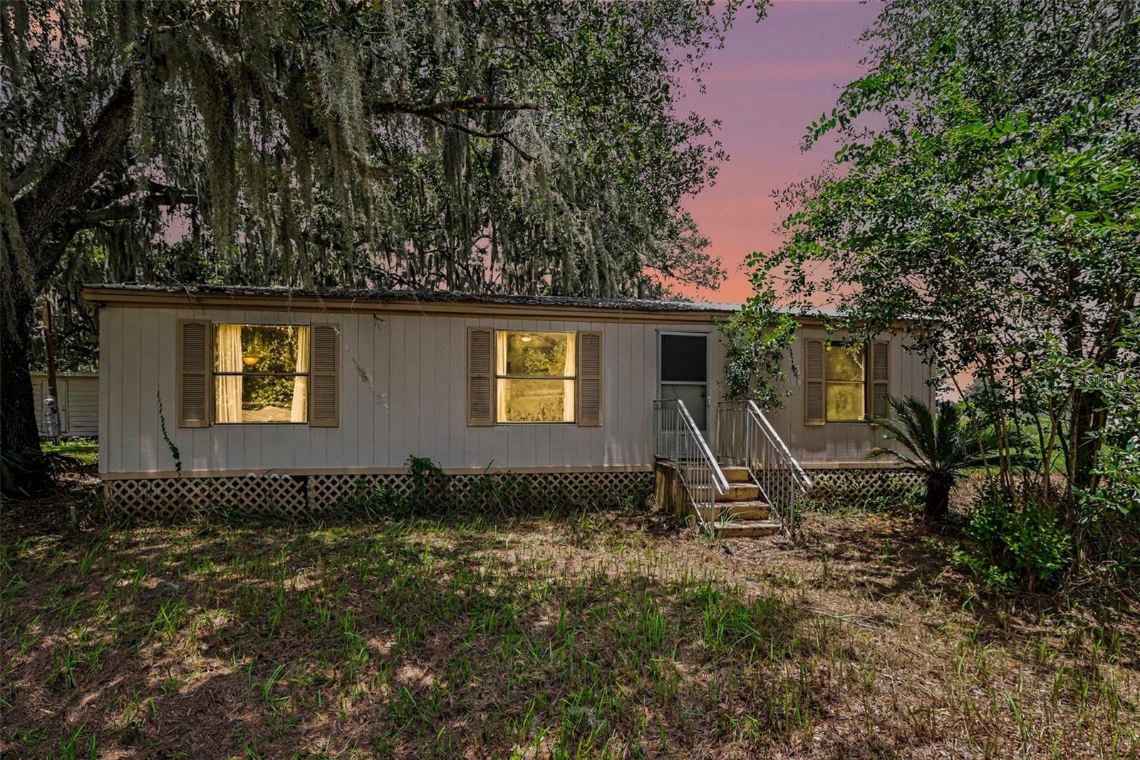 Over 5 acres of mostly cleared country land is just waiting for you to make it yours! The three-bedroom, two bath manufactured home sits in a shaded area not far from the beautiful little spring fed creek that cuts through the front corner of the property. Inside, the kitchen features wood cabinetry, granite-look countertops, a decorative metal backsplash, and wood-look flooring that continues into the dining area. The ample living room and split bedroom design provide comfortable and private space. The utility building attached to the main home offers washer/dryer hookups and additional storage space. The property includes a large shed with power and water, two large metal storage containers, and a covered lean-to type shed and chicken coop area.  Fields of cleared land await your desires, zoned Agricultural Rural- bring your horses and farm animals, plant veggies, or just enjoy the beautiful, peaceful view!

The property is located in flood zone X and has no HOA. The 5-acre parcel offers room for storage, outdoor use, and a rural setting while remaining in Lithia with access to surrounding communities and area amenities.