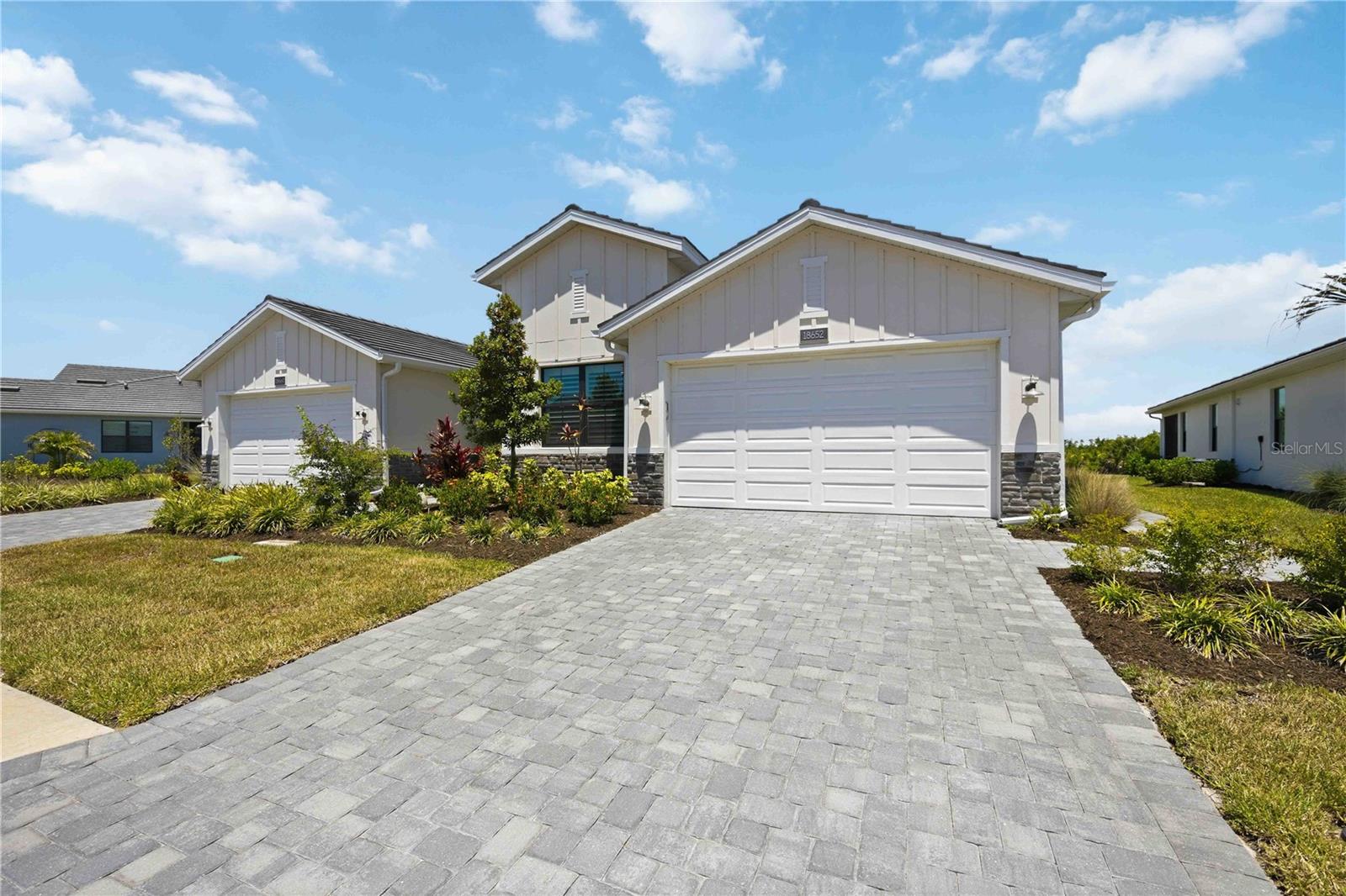 Welcome to Solstice at Wellen Park, where this better-than-new Toll Brothers Dunnet model villa stands apart as one of only two 3 bedroom villas in the area — offering over 1,800 SF of thoughtfully upgraded living space without the wait or uncertainty of building new. Built in 2024 with a coastal elevation, this home was constructed to a higher standard from the ground up, featuring full impact windows and doors, an impact-rated garage door, and a swing-out architectural entry door with decorative glass. Inside, 8-foot solid-core doors, a surge suppression panel, and a door and window alarm system deliver peace of mind, while motorized shades on the sliding glass doors and hurricane shades on the lanai add both storm protection and everyday privacy. The kitchen shines with KitchenAid appliances, soft-close drawers, cabinetry upgraded all the way to the ceiling with under-cabinet lighting, and premium hardware throughout. Both showers are fully tiled to the ceiling; the second bath features a shower in place of a tub. Comfort height toilets. Tray ceilings in the primary bedroom and great room. A gas dryer, laundry room cabinetry, upgraded Wi-Fi, plantation shutters, fandalier in the dining area, custom primary closet, and epoxy garage floor round out an upgrade list that would cost significantly more to replicate in a new build today. Internet, cable TV, a roof reserve & landscape maintenance are included in the HOA Fees.