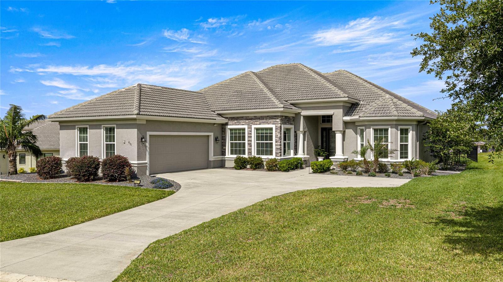Imagine living in a stunning Westchester-style Estate Home perched at 220 feet above sea level in the highly sought-after gated community of Roberts Ridge within the amenity-rich community of Terra Vista. This “just the right size” home offers the perfect balance of luxury, comfort, and functionality — all wrapped in beautiful architectural design and exceptional curb appeal. From the moment you arrive, the impressive architectural frontage, expansive courtyard drive, and spacious 3-car garage create a grand first impression. Step through the elegant fused-glass entry doors and your eyes are immediately drawn through the spacious living room to the inviting oversized lanai beyond. Inside, serene designer accent walls, tray ceilings, crown molding, luxury tile flooring, and a custom built-in entertainment center create an atmosphere of relaxed sophistication. The gourmet kitchen is designed to impress, featuring quartz countertops, custom cabinetry, a functional service island, stylish backsplash, and two oversized pantries — truly a dream space for cooking and entertaining. The open-concept layout flows beautifully, making gatherings with family and friends both effortless and elegant. Abundant natural light pours into the home through large glass doors and transom windows, enhancing the warm and inviting feel throughout. Step outside to the expansive lanai designed for every style of Florida living and relaxation. One side features a fenced dog run perfect for Fido, while the other offers an open sunning area ideal for soaking up the Florida sunshine. The spacious Owner’s Suite is a private retreat complete with large walk-in closets, dual vanities with a dedicated makeup area, and an oversized walk-in shower. Guests will appreciate the privacy of the separate guest wing featuring two generously sized en-suite bedrooms tucked behind a sliding entry door for additional comfort and seclusion. The large office/den offers exceptional flexibility with two built-in armoire closets and shelving, making it easily suitable as a fourth bedroom or multi-purpose space. A spacious laundry room with folding area and utility sink, along with the oversized 3-car garage, further showcase the thoughtful functionality built into every inch of this home. Additional upgrades include quality blinds, custom window treatments, designer lighting fixtures, and numerous finishing touches throughout — everything has been thoughtfully done for you. Beyond the home itself, Roberts Ridge offers an incredible lifestyle with friendly neighbors and endless activities within Citrus Hills. Enjoy pickleball, golf, tennis, bocce, swimming, fitness center workouts, relaxing spa days, dancing at the Tiki Bar, social events, and even a dog park for your furry family members. With three restaurants, countless clubs, and year-round entertainment, this is Florida living at its very best.