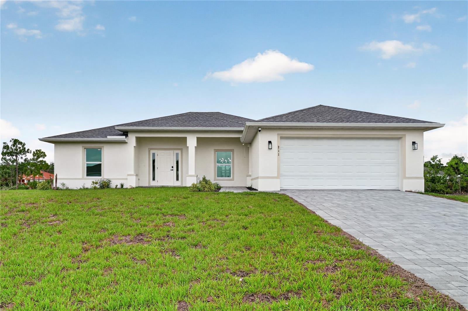 One or more photo(s) has been virtually staged. A few photos have been virtually staged. Impact Windows-Non Flood Zone-Additional vacant lot-Canal Frontage. Be the First to live in this BRAND NEW 2026 WATERFRONT 4 bedroom, 3 bathroom, 2 car garage paver driveway home on 3 Lots-one is adjoining and vacant.. NOT IN A FLOOD ZONE and Has IMPACT WINDOWS. Stainless Steel Appliance Package included. A spacious and open 1684 sq ft of living area with vaulted ceilings, beautiful marble look tile floors throughout, cathedral ceilings, a oversized living room overlooking the water with sliding glass doors leading out to the patio, a well appointed dining area with designer lighting that overlooks the canal, a perfectly designed island kitchen-with designer lighting, soft-close cabinetry and solid surface countertops. Roomy Primary bedroom with patio access, walk-in closet and built-in closets, dual sink and large walk-in shower. 3 split generous sized guest bedrooms. One has direct access to the screened patio and a full private bathroom with full shower. All bathrooms have smart mirrors to control lighting. Designer ceiling fans in all bedrooms and the familyroom. Also a 16x4 laundry room that leads out to the double garage. Walk out to your inviting brick paver screened enclosed patio to watch all the wildlife. The lot to the left is included in this sale. Makes for a great primary home or winter retreat. Close to restaurants, schools and shopping. Note: last photos with furniture were virtually staged with the furniture.