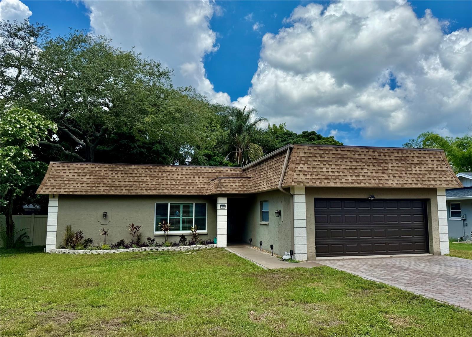 This pool home is located in the sought after Spanish Oaks neighborhood of Palm Harbor.  Featuring 3 bedrooms and 2 bathrooms in a 1609 square foot split floor plan.  The kitchen features plenty of storage with a separate pantry annd offers stainless appliances, granite countertops and plenty of cabinets and an additional area that can be used as a family room with the cozy wood burning fireplace.  Spacious living room dining room area will accommodate all of your social gatherings. Primary bedroom features an en-suite bath and walkin closet.  The split plan features two bedrooms and a hall bath on the other side.  The garage door was installed in May 2026 as was the garage side entry and patio door in the dining room, most of the remaining windows and doors in the home are double pane for energy efficiency (patio door in family room is the exception). Roof was done in 2024.  Electric tankless hot water heater provides endless hot water and energy efficiency.   Pool has a lovely pavered apron and allows for great entertaining space and enjoyment.  A vinyl fence in the back yard provides for privacy and low maintence.  We look forward to showing you this home, make your appointment today!