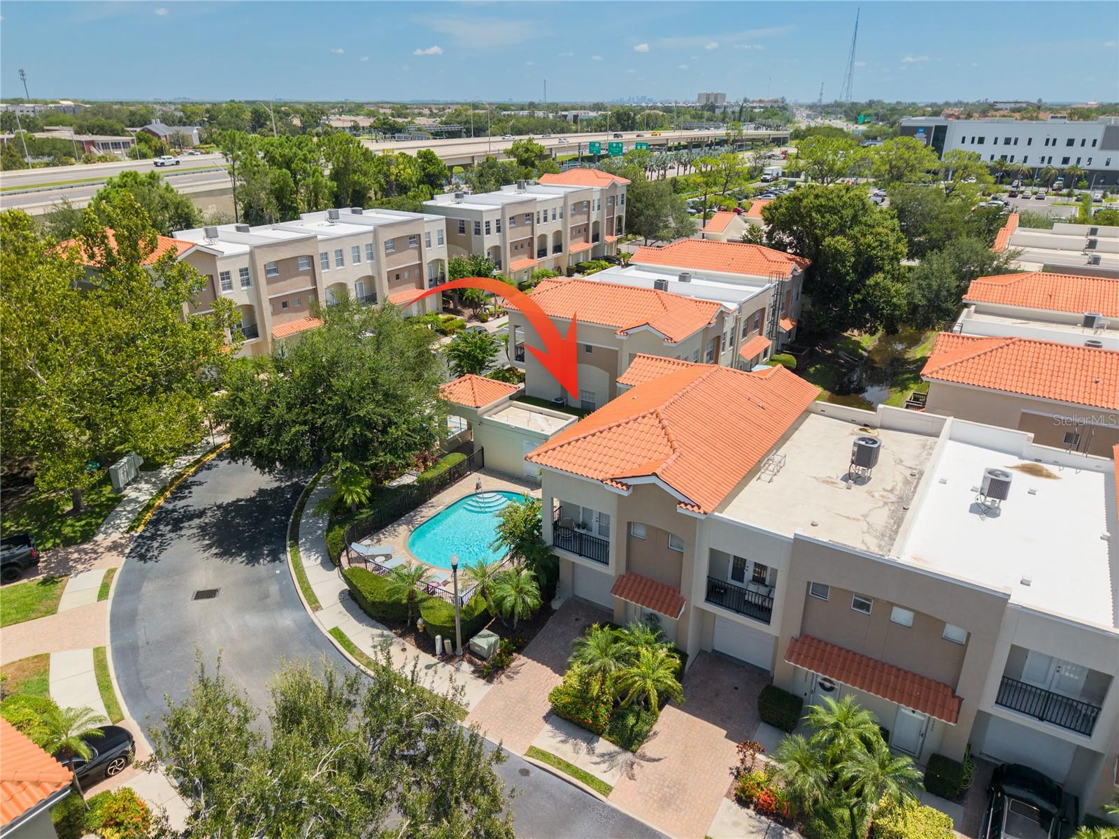 Want access to everything Tampa and St. Petersburg can provide? Well then, welcome home! Your gated community townhome is ideally located with convenient access to both sides of Tampa Bay and features 3 beds, 2.5 baths, 1,445 SF and a 1-car garage.  The community is beautifully landscaped with lush vegetation and features a community pool. The home is situated adjacent to the community pool just a few steps away. Downstairs is where you'll find high ceilings topped with crown moldings. The living room and dining room are open concept. The kitchen with wood cabinets and granite countertops, has an adjacent walk-in pantry steps away. A first floor half-bath (perfect for when you have guests over), access to your garage (providing plenty of room for storage), and access to your back patio are all just off the living room. A hallway closet at the bottom of the stairs provides additional storage. At the top of the steps you'll find your laundry closet with a washer and dryer included with the home. Your spacious primary bedroom is complete with an en-suite bathroom, walk-in closet, and a balcony for you to enjoy a breath of fresh air. The primary bedroom walk in closet has access to a large attic, providing additional storage space. There are two more bedrooms, each with generously sized closets and access to the guest bathroom. One of the guest bedrooms has a balcony, unique to this community, which overlooks the pool and pool deck. The central air conditioning system was completely replaced in 2023. Looking for privacy with the ability to enjoy and experience all of the Tampa Bay area, then look no further! Downtown St Pete – 6 miles, Pinellas beaches - 13 miles, Tampa Airport – 13 miles.