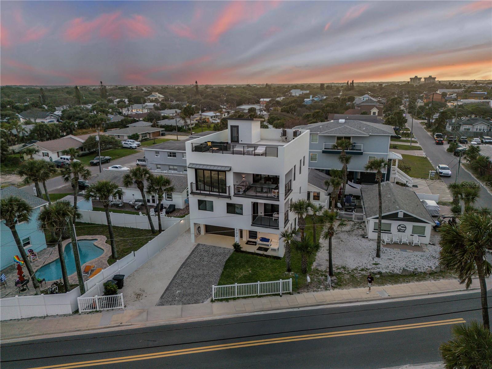 Under contract-accepting backup offers. Experience elevated coastal living in this exceptional ocean-view property in New Smyrna Beach. Spanning over 4,400 total square feet, this unique offering includes two residences with a combined 7 bedrooms and 5.5 bathrooms, a private pool, and an unbeatable location just moments from the beach, dining, and shopping. Situated in a highly desirable short-term rental zone, this property presents incredible flexibility and income potential. The main home features a stunning rooftop deck with panoramic Atlantic Ocean views and a private elevator providing seamless access to all levels. Live in one residence while generating revenue from the other, or continue operating as a turnkey vacation rental investment. Designed with a modern coastal aesthetic, both homes showcase open-concept layouts, abundant natural light, and stylish finishes throughout. Spacious bedrooms provide a comfortable retreat, many with beautiful water views and inviting coastal ambiance. Outdoors, enjoy a private pool and multiple entertaining areas, perfect for relaxing or hosting guests. Take in ocean breezes, breathtaking sunrises, and the soothing sound of the waves from multiple vantage points, including the expansive rooftop deck. Ideally located within walking or golf cart distance to all that New Smyrna Beach has to offer, this property provides easy access to pristine beaches, local restaurants, boutique shopping, and a variety of outdoor activities. Whether you're seeking a primary residence, vacation home, or high-performing investment, this rare opportunity delivers the best of luxury, location, and lifestyle. Schedule your private showing today!