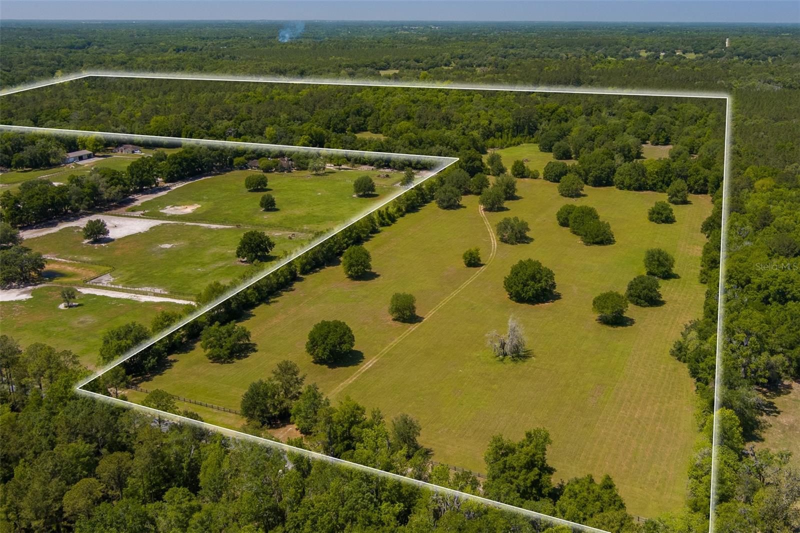 This 99+ acres is nestled just 14 minutes from the World Equestrian Center and 8 minutes from HITS! The property features open pastures scattered with majestic oak trees, offering the perfect blend of open space and natural shade. Tucked away in a more heavily wooded section of the property sits a two-story home with classic wood siding, featuring 3 bedrooms and 1.5 bathrooms. Whether you're envisioning a peaceful country retreat, an equestrian estate, or a unique investment opportunity near Ocala’s thriving equine scene, this property offers endless potential in a truly prime location!