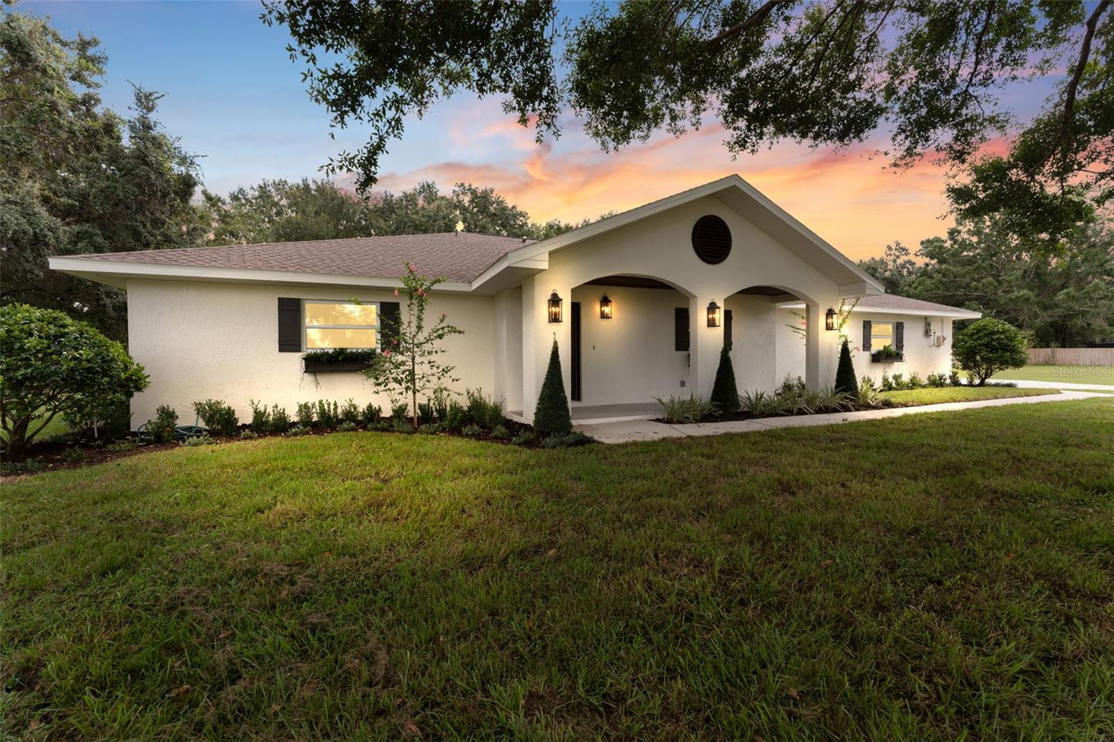 **BACK ON THE MARKET**  Turn-Key Renovated Pool Home on a Sprawling Lot. When ordinary just won't do. This completely renovated single-level home was reimagined by a professional interior designer — and the result is turn-key living with real substance behind the sizzle. Start with the savings: $50K in solar panels means an electric bill of just $13. Add a brand-new septic tank and drainfield, new well pump, and new water conditioning system, and this is a home where the big-ticket items are already taken care of and your monthly $ outflow is next to nothing! Inside, every detail has been refreshed — new doors and windows, new flooring and paint throughout, new light fixtures, and a cozy fireplace anchoring the living area. The kitchen is the showstopper: upgraded appliances, a statement range hood, a drawer microwave, sleek new cabinetry, and an expansive center island topped in stunning quartz — built for both everyday meals and easy entertaining. The split-bedroom layout gives everyone their space. The primary suite features a beautifully updated bath and a large closet with custom built-ins, while the over-sized secondary bedrooms offer generous room for family or guests. Step outside to your own private oasis: a gorgeous pool and spa, a screened lanai, elegant brick pavers, and mature landscaping for privacy. The oversized lot leaves plenty of room to build a generous detached garage if desired. Move-in ready, meticulously updated, and full of upside. This rare pool home won't last — schedule your showing today.