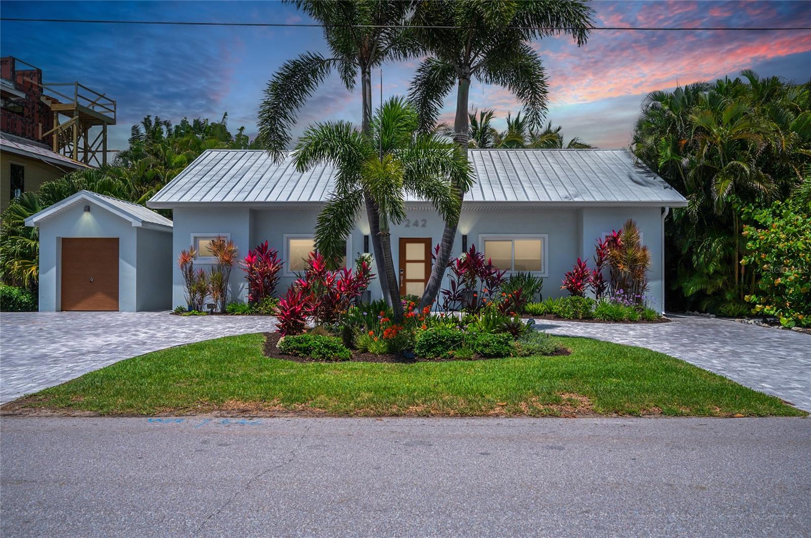 Named "A Wave From It All" by the sellers, this exceptional coastal property offers high-end finishes and a layout designed for seamless indoor/outdoor living. The outdoor pool area serves as a private tropical oasis, perfect for relaxation.

The main residence features three bedrooms, each with a king bed and ensuite bathroom. The kitchen is equipped with a Sub-Zero refrigerator, a Wolf range and microwave, Bosch dishwasher and wine cooler. For ultimate privacy, the primary suite is accessed through a unique bookcase doorway. This home comes furnished and includes original artwork by renowned artists and a beautiful outdoor mural by Chad "Cheeta" Ruis.

The property also includes a versatile casita featuring two Murphy beds, a half bath, an office area, a laundry room, and a convenient outdoor shower located just outside the half bath which includes both hot and cold water. A small storage garage is available on-site for bikes and beach gear.

Located on the North end, the home is a short walk from Bean Point beaches, Bayfront Park, and the boutiques and dining on Pine Avenue. Additionally, the adjacent 10,600+ sq. ft. parcel at 240 Gladiolus is available for separate purchase. It is currently landscaped to enhance the estate and includes a large garage.

Don't miss out on this unique opportunity and schedule your private showing today!