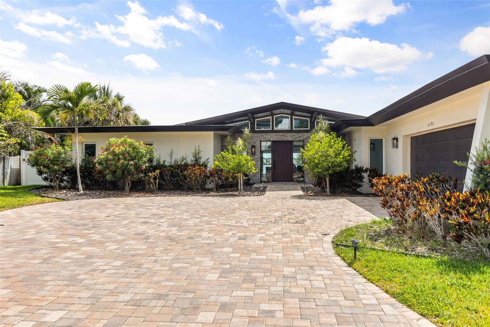 Welcome to paradise and bring your boat for this waterfront home with private dock and boat lift.  This 4 bedroom 5 bath tranquil beauty is in the heart of the Intracoastal open water. Entering into the primary bedroom, overlooking the open water Light and airy with tons of beautiful views of the water.  It's been newly renovated with top of the line, modern appliances and accessories throughout without losing it's midcentury roots.  Turn key ready to be privately enjoyed or perfect for guests and entertaining with a waterfront pool & hot tub as well as an outdoor kitchen.  It is in the highly sought after waterfront community, Harbor Hills, which is near Largo Central Park & Heritage Village as well as Indian Rocks Beach and the highly-rated Clearwater Beach.