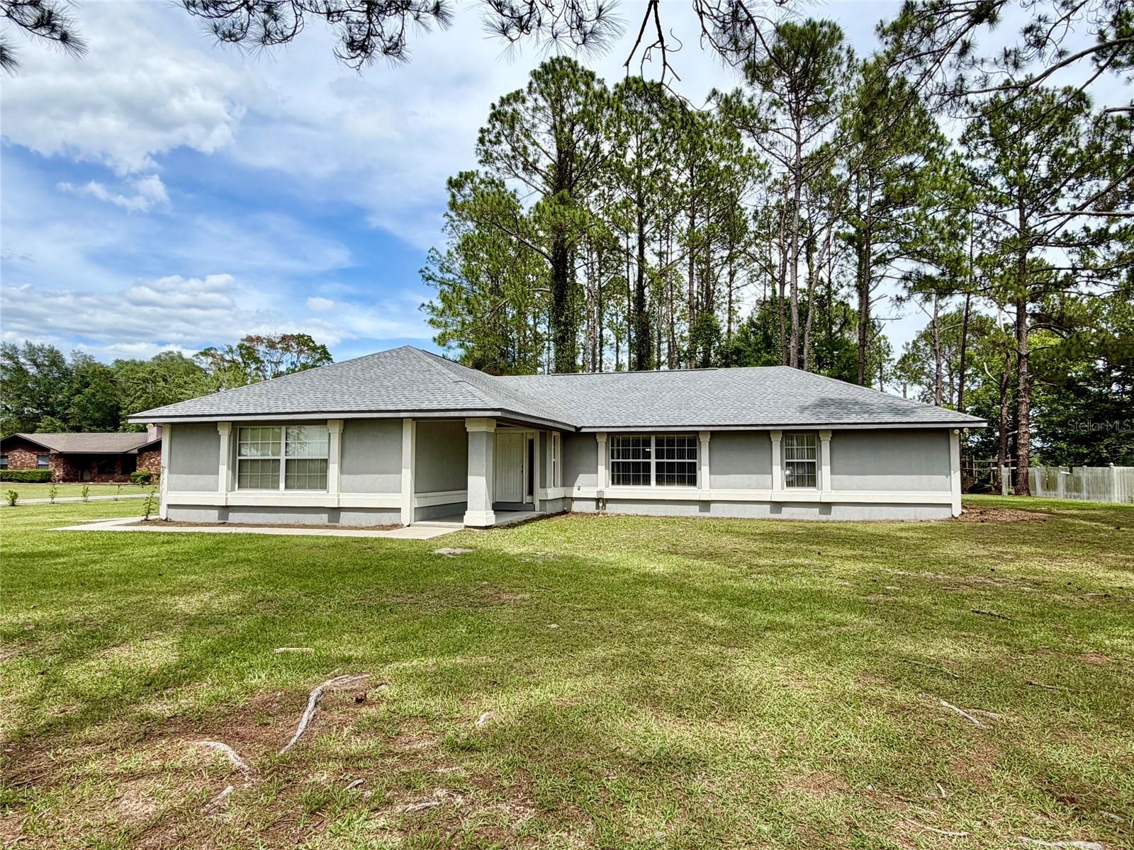 Welcome to this 3-bedroom, 2-bathroom home on 1 acre in the Oak Manor neighborhood in Union County that is for sale! This is where peaceful country living meets everyday convenience. Nestled in this quiet neighborhood, with NO HOA just outside of Lake Butler, this home offers the space, privacy, and relaxed lifestyle you've been looking for at an affordable price. This charming residence features a 2 year old roof, newer LVP flooring throughout (no carpet) and a comfortable split floor plan with nice-sized secondary bedrooms and a full bathroom on one end and an oversized owner’s suite with a walk-in closet and bathroom on the other end. There is an expensive-screened back porch with windows that easily convert it into a Florida Room that extends your living space and overlooks the large yard. There is an interior laundry room and a 2-car garage for plenty of storage or parking. This 1-acre lot provides plenty of room for gardening, outdoor entertaining, pets, or simply enjoying the beauty of North Florida's open spaces. Mature trees and the peaceful setting create the perfect backdrop for morning coffee on the porch or evenings under the stars. Whether you're a first-time homebuyer, looking to downsize, or searching for a quiet retreat away from the hustle and bustle, this property offers endless possibilities. Located on a paved road and just minutes from downtown Lake Butler, you'll enjoy the best of both worlds—small-town charm with convenient access to Gainesville, Lake City, Starke and surrounding areas. Come experience the tranquility, privacy, and value that make this Lake Butler property such a special place to call home!