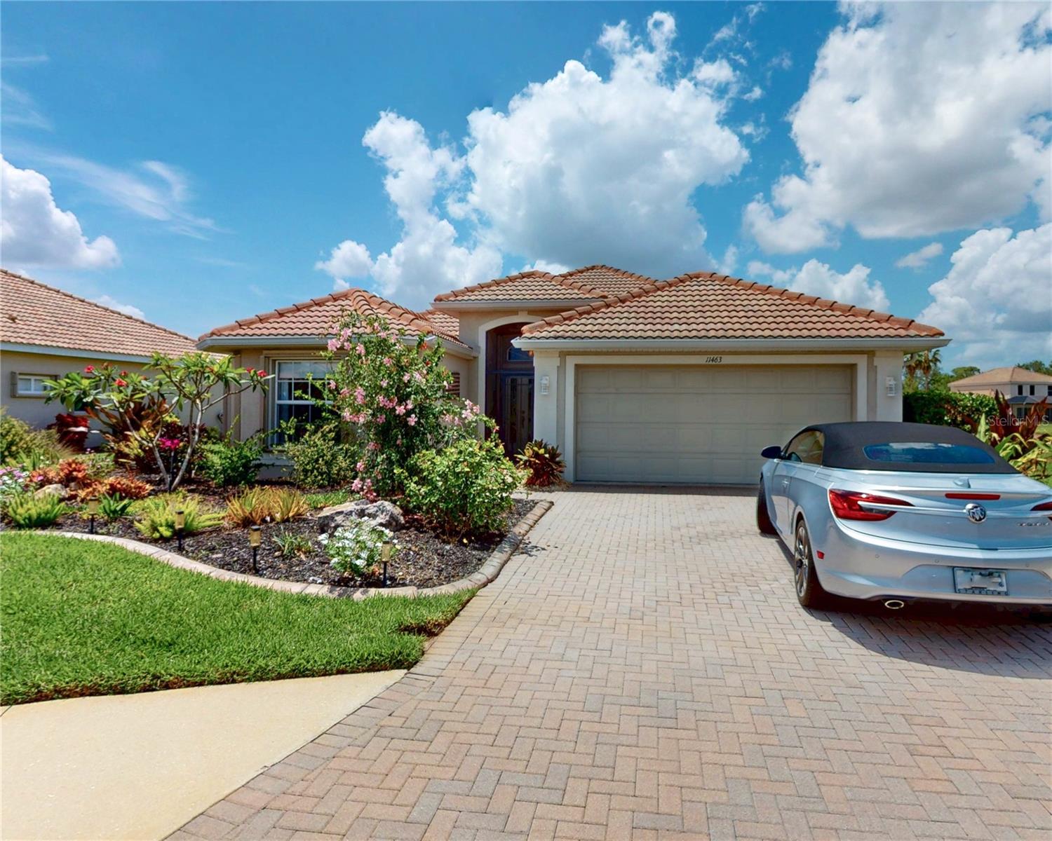 This custom-appointed home offers resort-style living with high-end finishes. A paver driveway and entry lead to an interior featuring 9-foot ceilings, a tray ceiling, and ceiling fans in all rooms. Flooring includes 18x18 tile in main areas and wood laminate in bedrooms. The open-concept layout includes a living/dining room combination and a gourmet kitchen with stainless steel appliances, granite/quartz countertops, a large pantry, and an island with bar seating. A separate laundry area provides a utility sink and storage cabinets. The home features three full bathrooms, including two luxurious en suites. The primary suite is a private retreat with his-and-hers closets and a lavish bath complete with a soaker tub and a separate water closet. Outdoor entertaining is optimized by an oversized covered lanai, a private hot tub, and a dedicated pool bath for convenience. Stoneybrook Community Amenities: This secure, gated community offers a stunning resort-style pool, fitness center, and a fully equipped clubhouse with a kitchen, library, and media room. Recreational facilities include courts for pickleball, tennis, sand volleyball, and basketball, along with a baseball field. The vibrant social calendar features frequent community events, including coffee club, Mahjong, Bingo, Poker, Food Truck Wednesdays, and family-friendly gatherings. Conveniently located with easy access to I-75 and just minutes from Venice's best beaches, dining, and shopping.