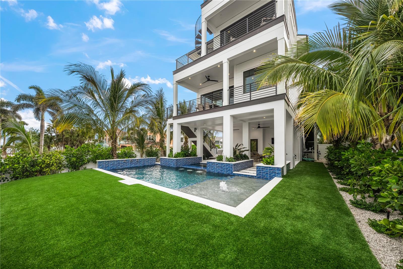 Welcome to your ultimate waterfront retreat in Bradenton Beach. This extraordinary direct bayfront estate defines the very best in coastal luxury living. Spanning 3,005 sq. ft., this stunning residence is masterfully designed for comfort, style, and effortless enjoyment, offering 5 spacious bedrooms and 5.5 beautifully appointed bathrooms—a rare opportunity ideal for multigenerational living or hosting guests in absolute comfort.
Every detail has been thoughtfully curated, from the 3-car garage to the private elevator that offers seamless access to all levels of the home.
Step inside to an expansive open-concept great room, where natural light and water views pour in through oversized windows. The living, dining, and kitchen spaces flow together with ease, creating a warm and inviting setting for both intimate gatherings and lively entertainment. The generous dining area opens to a covered bayfront terrace, the perfect backdrop for al fresco meals framed by serene, sparkling water views.
The chef’s kitchen is a showpiece. The large center island is designed for both culinary creativity and casual conversation. Every element balances beauty and function, making it the true heart of the home.
Ascend to the rooftop deck, where sweeping, unobstructed panoramic views of the Bay stretch endlessly in every direction. This elevated vantage point offers one of the island’s most memorable spots to savor breathtaking sunsets and the peaceful rhythm of coastal living.
Outside, your private oasis awaits. A covered patio and heated pool with spa provide year-round relaxation, while the brand-new dock and lift offer unmatched access to the water, which makes it ideal for boating, paddleboarding, fishing, or simply soaking in the tranquility of the Bay.
Perfectly situated, the home is just steps from the sugar-sand beach and a short stroll to lively Bridge Street, where charming boutiques, restaurants, and entertainment create the ultimate island lifestyle.
A residence of this caliber is truly rare. “Daytime” blends exceptional design, luxurious amenities, and awe-inspiring views into a waterfront retreat that is truly extraordinary. Make your appointment to tour, as this is a home that must be seen to be fully appreciated.