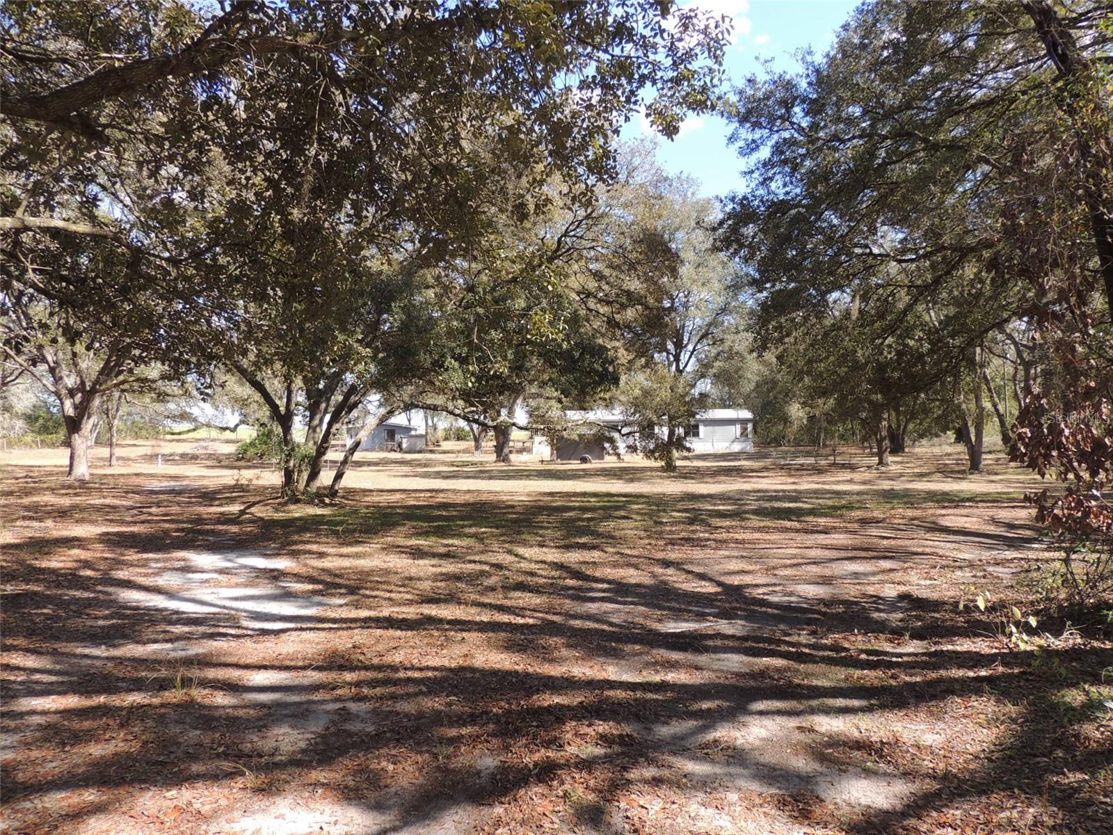 PURE COUNTRY LIVING ON OVER 5 ACRES in MORRISTON, FLORIDA. Experience the freedom of wide-open spaces with this 3 bedroom, 2 bath manufactured home set on 5.1 scenic acres in Morriston. Offering 1,620 square feet of comfortable living area, this property blends practical upgrades with the peaceful beauty of true North Central Florida country living. Shaded by mature, sprawling oak trees, the homesite provides a welcoming setting from the moment you arrive. The property is fully perimeter fenced with additional partial cross-fencing, making it ideal for animals, gardening, or creating separate use areas across the acreage. A vinyl fencing along the road adds curb appeal, while the expansive land offers plenty of room to roam, work, or relax in total privacy. The home features a durable metal roof, skylights that brighten the kitchen and primary bathroom with natural light, and a tankless LP gas water heater for efficient, on-demand hot water. Outdoor living is just as inviting with a generous 12' x 27' side deck—perfect for morning coffee, evening gatherings, or unwinding under the oaks. For those needing space for projects or storage, the property includes a concrete block detached garage and a separate 24' x 12' workshop, offering flexibility for hobbies, equipment, or small business use. 

If you’ve been searching for room to spread out while still being within reach of nearby towns, this Morriston acreage delivers the ideal blend of comfort, function, and rural charm. Make the move to pure country living and enjoy the space, privacy, and lifestyle you’ve been dreaming of.