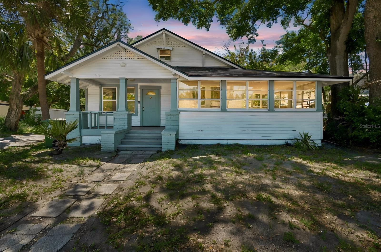 Virtually Staged. Beautifully renovated 1925 Craftsman bungalow blending original character with a full top-to-bottom modern refresh. Step inside to find a brand-new kitchen featuring crisp quartz counters, soft sage shaker cabinets, vertical shiplap accent walls, and a deep stainless sink with modern matte-black fixtures. New luxury vinyl plank flooring flows throughout, paired with fresh interior paint, crown molding, and original-style 5-panel doors that nod to the home's 1925 heritage. Both bathrooms have been fully updated with designer vanities, quartz tops, and brushed-nickel finishes. Stay comfortable year-round with brand-new ductless mini-split A/C units installed in every room — quiet, energy-efficient, zoned cooling and heating. A finished, air-conditioned attic-level bonus room adds flexible square footage perfect for a home office, studio, guest space, or playroom. Classic Craftsman charm shines on the exterior: a covered front porch with brick columns, decorative gable trim, and a gorgeous wraparound enclosed sun porch lined with banks of windows — the perfect spot for morning coffee or a Florida afternoon. The brand-new roof (2025) is one less thing to worry about. Outside, a fully fenced backyard surrounded by mature palms and shade trees offers privacy on a generous .31-acre lot. Located in a designated Opportunity Zone — a meaningful tax-advantage opportunity for the right buyer or investor — and within walking distance of Ballard Elementary, just minutes to downtown Bradenton, the Riverwalk, Manatee Memorial Hospital, and a short drive to the Gulf beaches of Anna Maria Island. Move-in ready with all the heavy lifting already done. Schedule your private showing today.