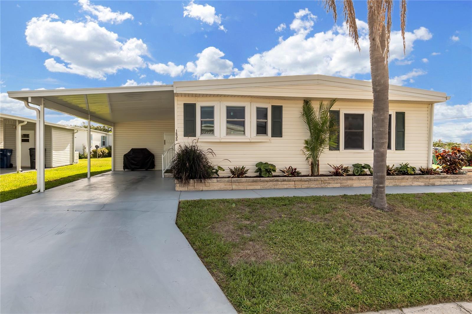 Virtually Staged. Welcome to Tidevue Estates, a sought-after 55+ land-owned community offering an active Florida lifestyle with low annual HOA fees of just $600. This beautifully updated 2-bedroom, 2-bath home features attractive landscaping with irrigated planters and an impressive list of recent improvements. Enjoy peace of mind with a BRAND-NEW ROOF, NEW Carport structure to include vertical posts and a re-enforced header beam for additional protection. NEW A/C System and ductwork, NEW Double-pane, Double hung Insulated Windows, ALL-NEW Sub-flooring, Vapor barrier, Vinyl  Flooring throughout, and NEW Drywall and Ceilings. This home has passed strict VA engineering requirements featuring new tie-downs. Fresh interior paint and recessed lighting create a bright, modern feel throughout the home. The REMODELED guest bathroom adds style and convenience, while the spacious bedrooms include a primary suite with en-suite bathroom. The OVERSIZED workshop offers abundant storage and workspace, complete with a window A/C unit for added comfort, and houses the washer and dryer. Relax with your morning coffee or unwind at sunset on the extended side patio, offering the perfect outdoor living space and potential for a future Florida room. Tidevue Estates is a golf cart-friendly community with PLENTY of social activities and amenities for residents to enjoy. Conveniently located just minutes from restaurants, shopping, medical facilities, and quick access to I-75, you'll also be within easy reach of Florida's beautiful Gulf beaches. Don't miss this opportunity to own a move-in-ready home in one of the area's most affordable and active land-owned 55+ communities. No pets permitted. Call today to schedule your private showing!