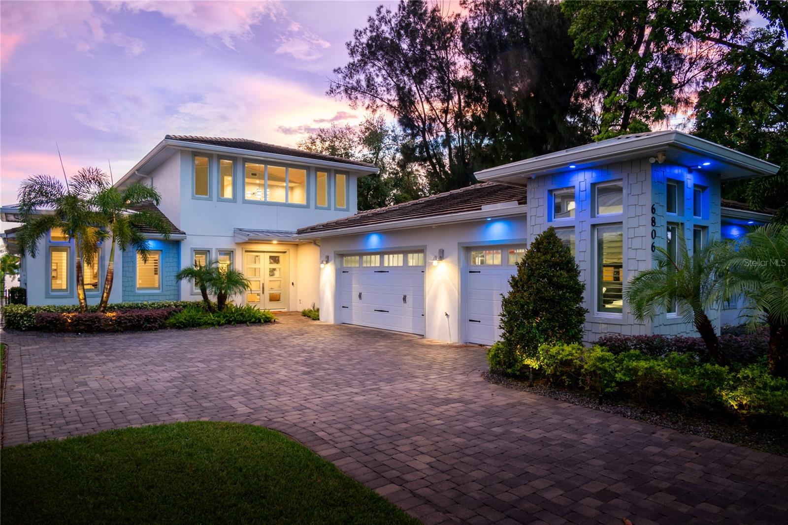 Nestled along the serene shores of the pristine Lake Conway chain of lakes, this coastal modern masterpiece embodies luxury living at its finest. Boasting over 70 feet of coveted waterfrontage, this stunning property offers a rare opportunity to indulge in waterfront bliss. Upon arrival, a grand entrance welcomes you, with a long driveway lined with majestic fox-tail palms, setting the tone for the elegance that awaits. The home's exterior is adorned with mature landscaping, expertly illuminated with uplighting, creating a captivating ambiance day or night. Step inside to discover an impeccably designed residence spanning 3,900 square feet, featuring four bedrooms and four and a half bathrooms, plus an office. Each bedroom offers the ultimate retreat with its own ensuite bathroom and spacious walk-in closet, ensuring comfort and privacy for all. The primary bathroom is a sanctuary unto itself, showcasing an oversized shower for two, perfect for unwinding after a day on the lake. Coastal modern finishes grace every corner, marrying sophistication with coastal charm. Entertain with ease in the expansive outdoor oasis, complete with a dock equipped with a dual motor lift for larger boats and a dual jet ski lift, catering to the avid boater's every need. Lounge by the sparkling pool, adorned with bubblers and accent lights, offering a refreshing respite on hot summer days. As evening falls, gather around the wood-burning fire pit pavilion, where stories are shared and memories are made under the starlit sky. For added convenience, the property features a mosquito misting system and phantom screens, ensuring uninterrupted enjoyment of the outdoors. The oversized 3-car garage provides ample storage for vehicles and recreational gear, while a stand-up attic offers additional space for belongings. Indulge in the epitome of lakeside luxury living at this breathtaking Lake Conway retreat, where every detail has been meticulously curated for the discerning homeowner seeking the ultimate waterfront lifestyle.