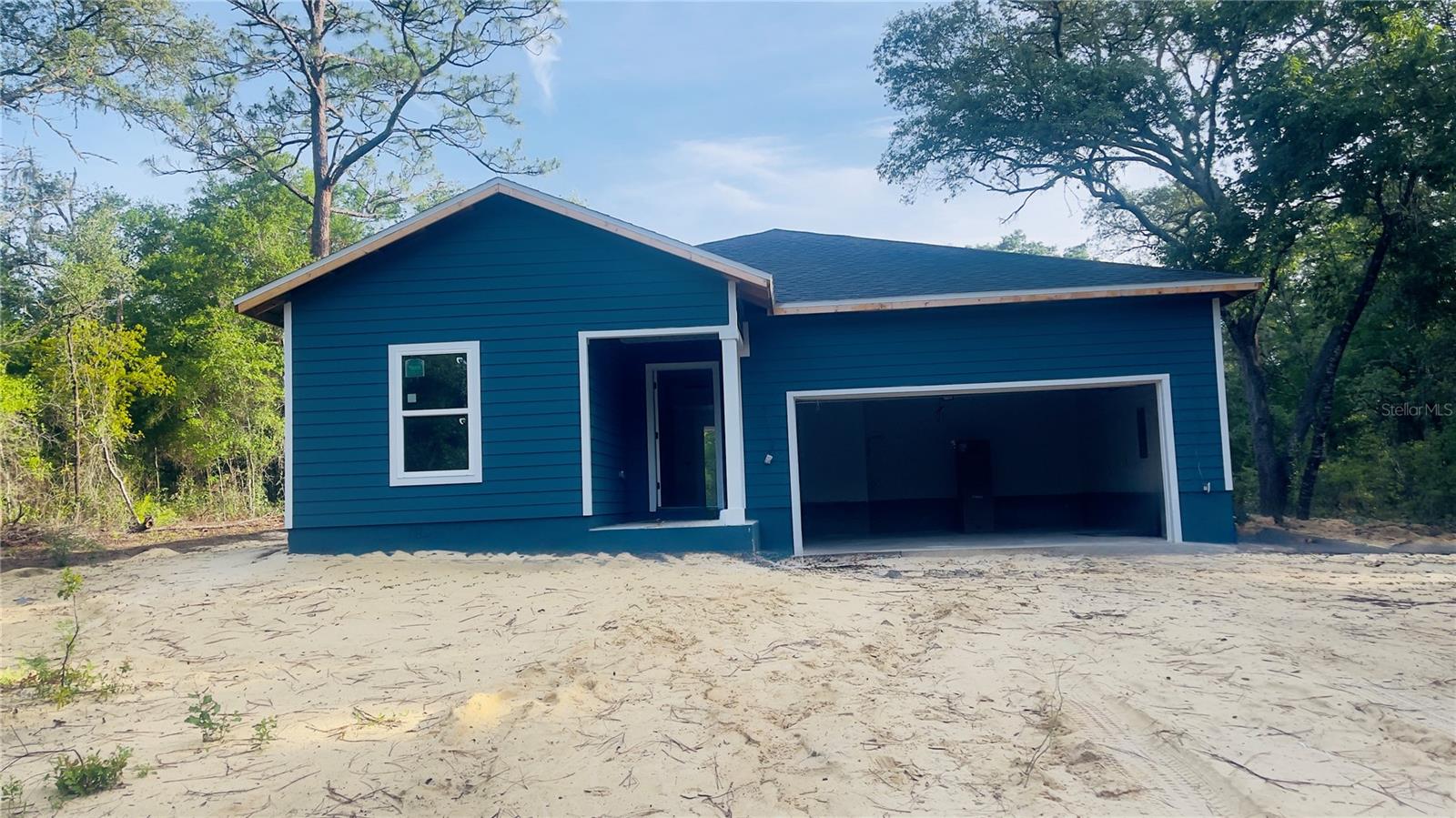 Under Construction. Interior photos are from a previous model and colors may be different. This cute & cozy 3 bedroom, 2 bath home sitting on a spacious 1.25 acre lot on paved county street offers quality craftsmanship with modern finishes. The interior features granite countertops, under-mount sinks, soft-close wood cabinetry, and a stainless-steel appliance package. Decorative tray ceilings with crown molding, luxury vinyl plank flooring throughout the main living areas, carpeted bedrooms, and updated fixtures contribute to the home's cohesive design. Large windows allow natural light to flow throughout the living spaces, creating a bright interior environment. The floor plan offers comfortable bedroom sizes and ample closet storage. Outside, the covered rear porch provides a place to enjoy the surrounding landscape, while mature trees offer shade across portions of the property. Plenty of space outside for animals, gardening, boat storage , etc. This brand new home offers a blend of thoughtful design, functional living space, and located just outside of the city limits. Short drive to schools, shopping, land local amenities while also being an easy commute to Gainesville or Ocala.