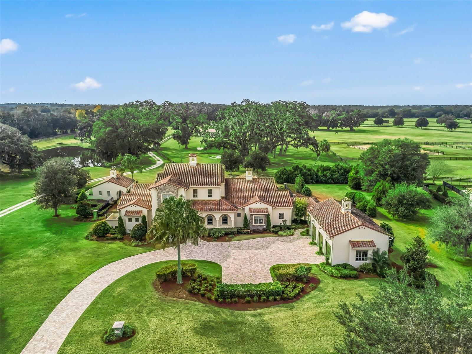 Elegant 19+ acre estate style farm in the gated Equestrian Community of Bel Lago, well located close the World Equestrian Center & shopping. This gorgeous horse farm boasts a custom built 6200+ sq ft pool home with a guest casita, 4-stall center aisle barn, large grass paddocks & nearby riding trails. The resort-style pool area overlooks the acreage & oak trees & has travertine decking & a large screened-in lanai with summer kitchen & fireplace. The home boasts luxurious high-end finishes throughout & has 4 bedrooms, 5 bathrooms plus two offices. Each bedroom has an en-suite bathroom for privacy. The gourmet kitchen has an enormous island overlooking the family room & lanai with plenty of space to entertain. The expansive primary suite is located on the main floor with 2 large walk in closets & a spa-like en suite bathroom. The home also has a large open loft area on the second floor with a balcony overlooking the grounds, in addition to the two guest bedrooms with bathrooms. Enjoy the Florida lifestyle by the beautiful pool and outdoor living area complete with a summer kitchen and fireplace. The private casita is located by the pool & is perfect for guests or a mother-in-law suite. There is a 3 car garage with additional washer & dryer & partially finished loft area above the garage for storage. Bring your horses & move right in to this elegant 19+ acre estate!